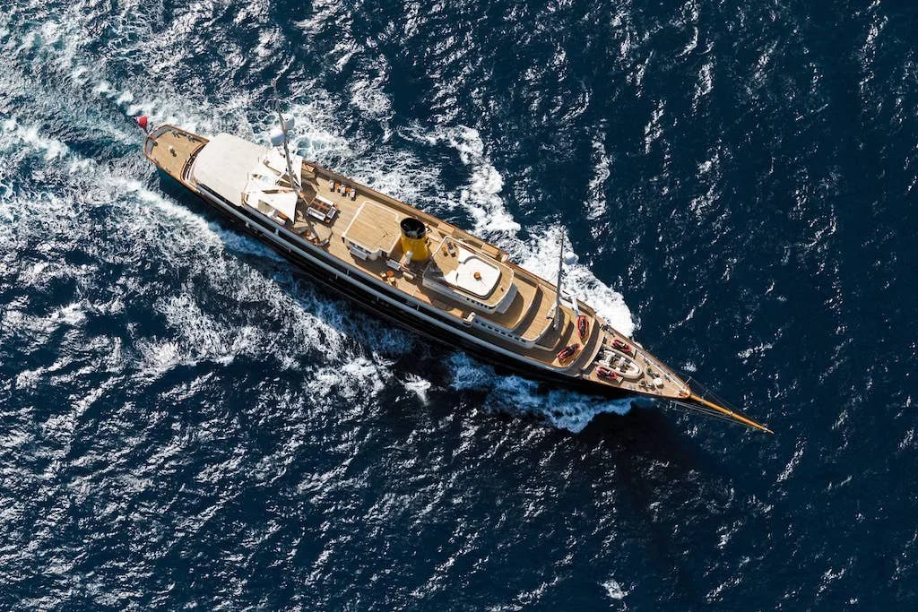 Aerial view of a large boat sailing on open blue water.