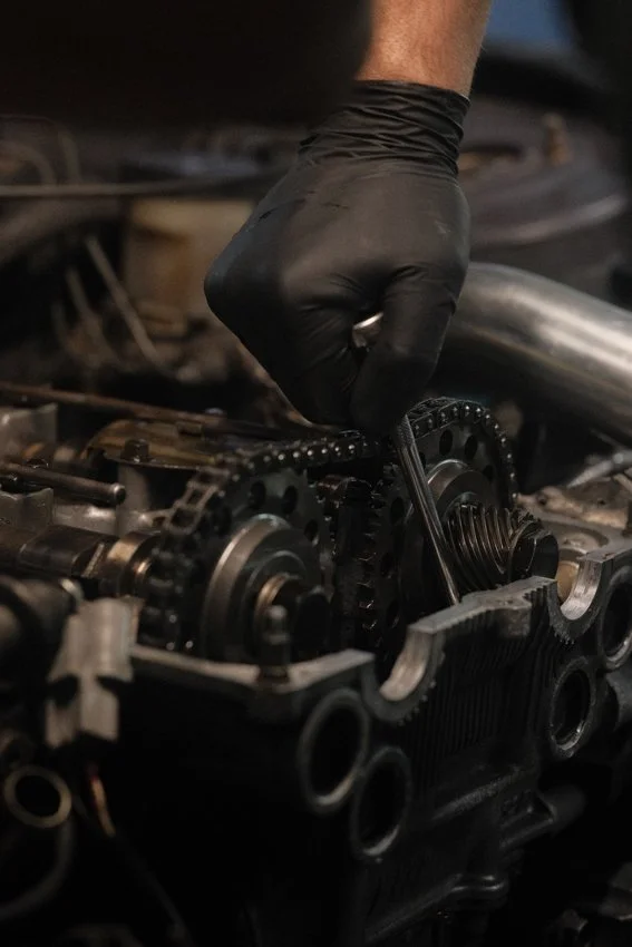 a mechanic is performing a repair on the inside of an engine.