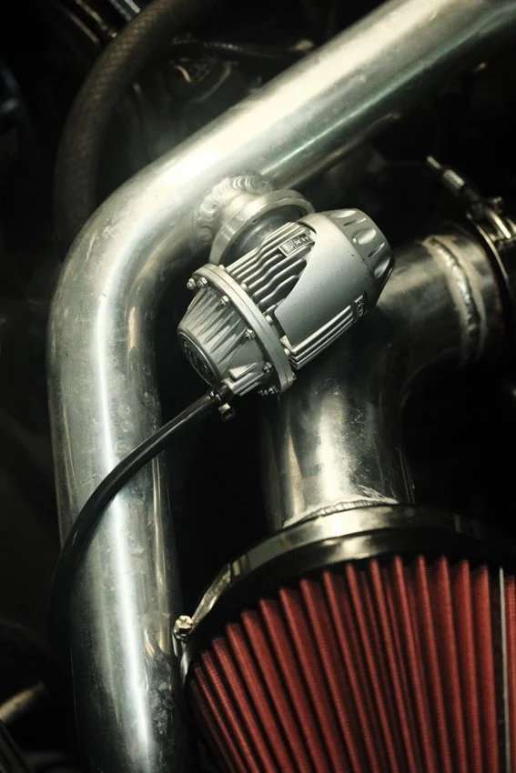 A close-up photo of an air filter and blow off valve from a turbocharged performance engine