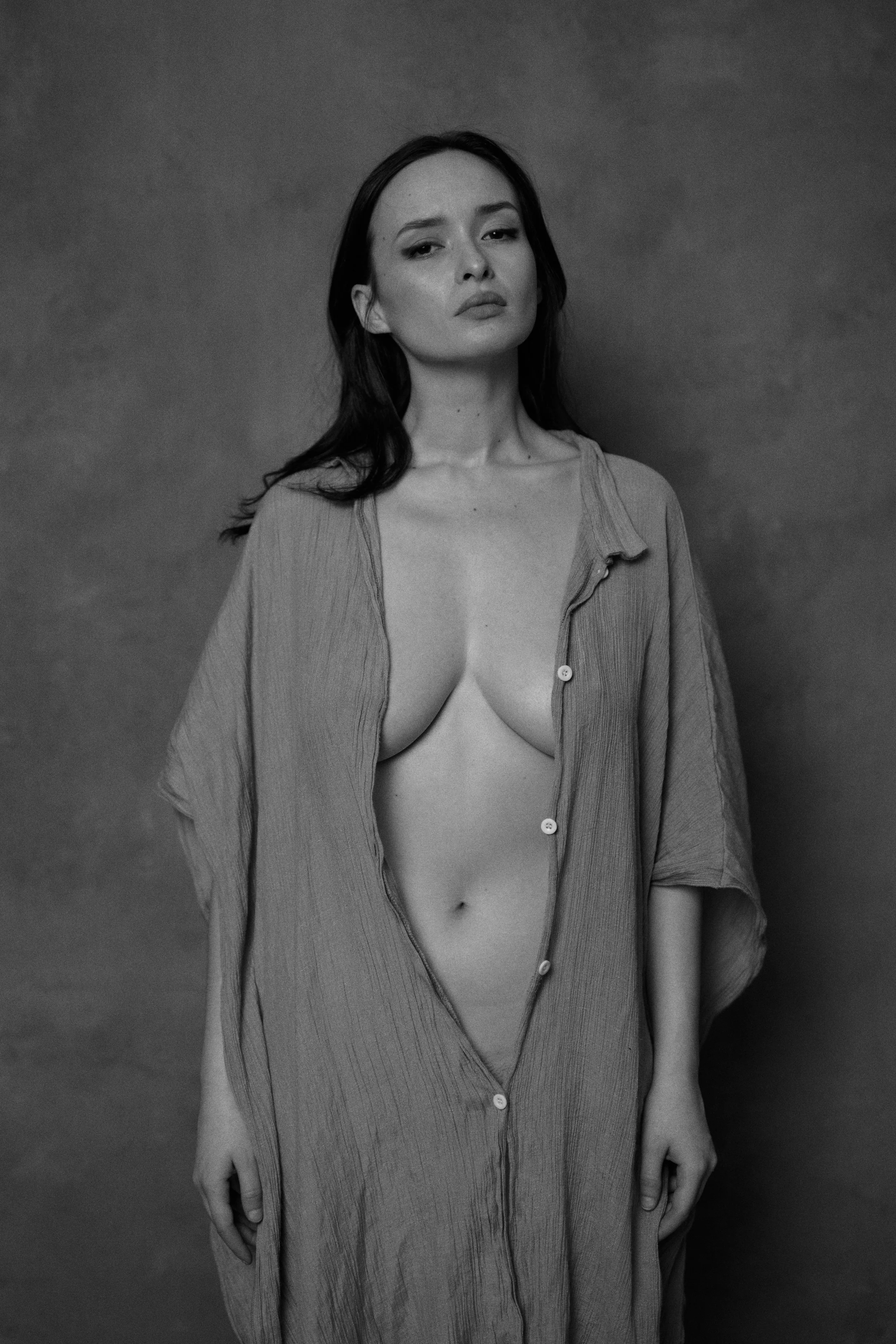 Schwarz-Weiß-Fotografie einer Frau, die ein offen getragenes Hemd trägt. Nude Art