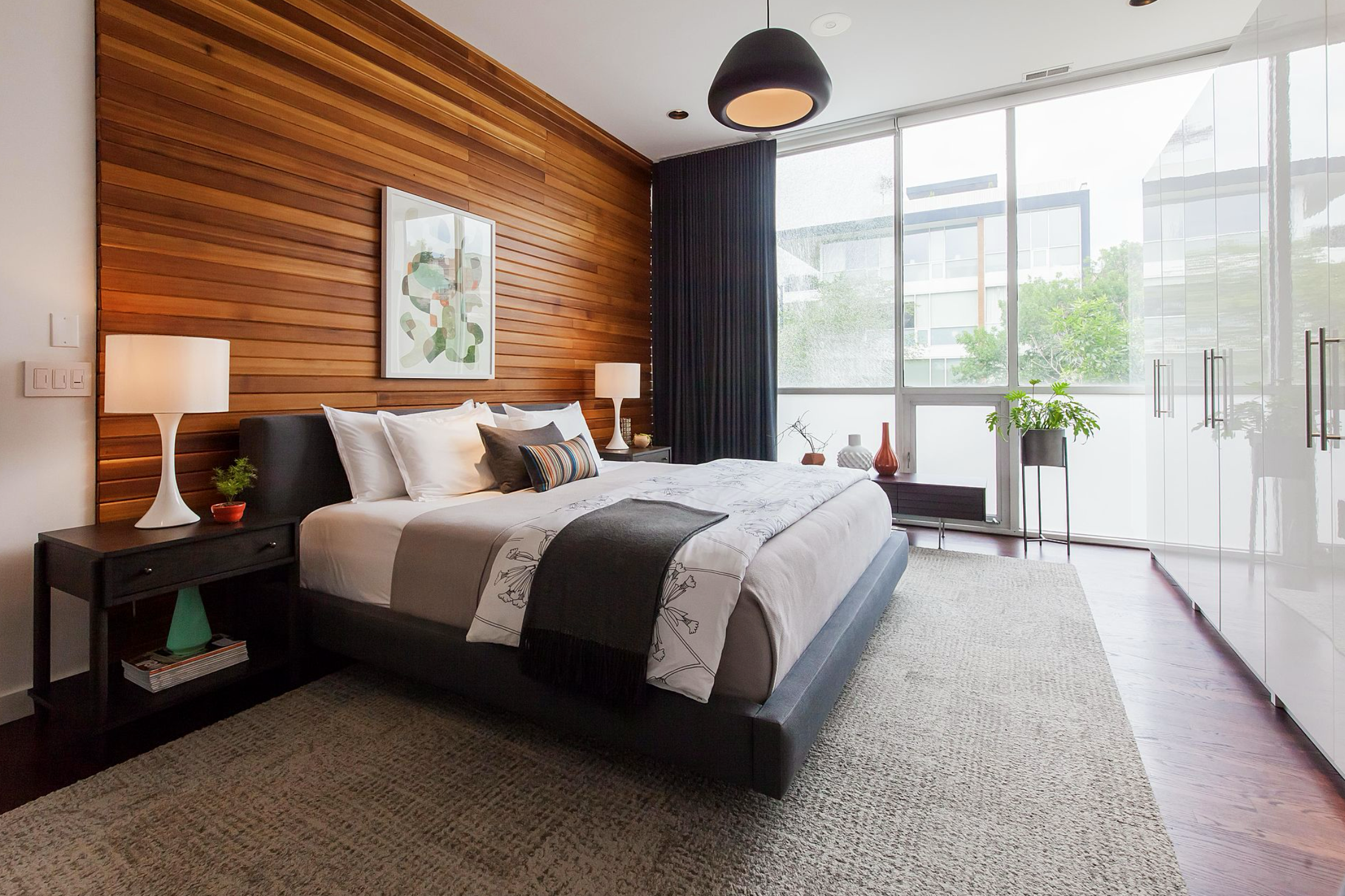 A modern Wicker Park bedroom with wood-paneled walls, soft natural light, and a clean-lined bed design—balancing warmth, texture, and urban calm