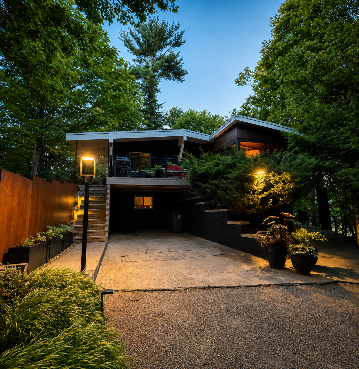 Mid-century modern home exterior at dusk, surrounded by mature trees, Fennville Michigan