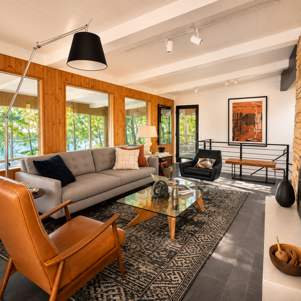 A warm and inviting living space that blends mid-century modern design with contemporary comfort. Natural wood paneling, clean architectural lines, a striking stone fireplace, and curated furnishings create a sophisticated retreat with timeless chara