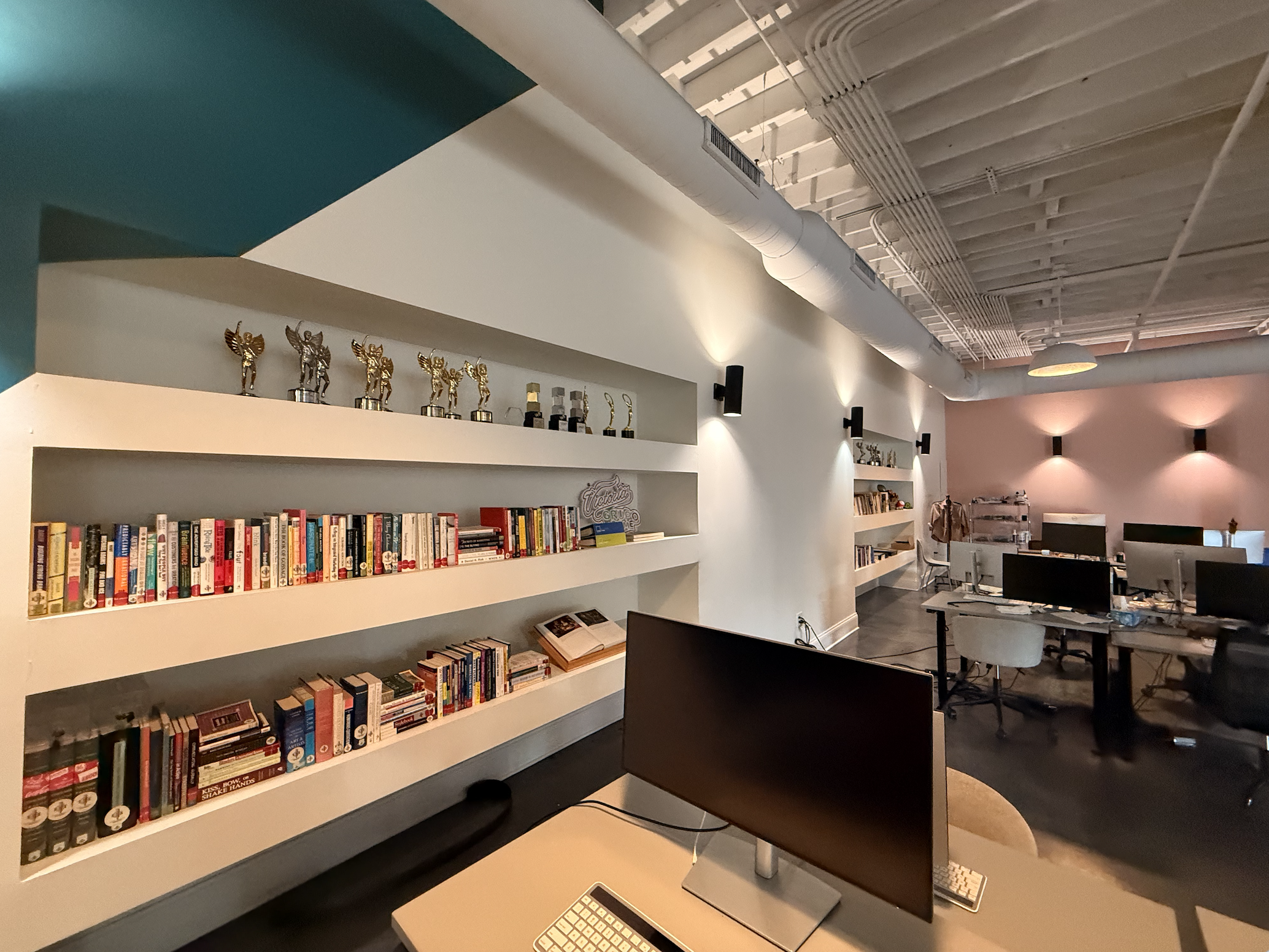 Agency Loft Workspace with Built-In Bookshelves and Awards Display
