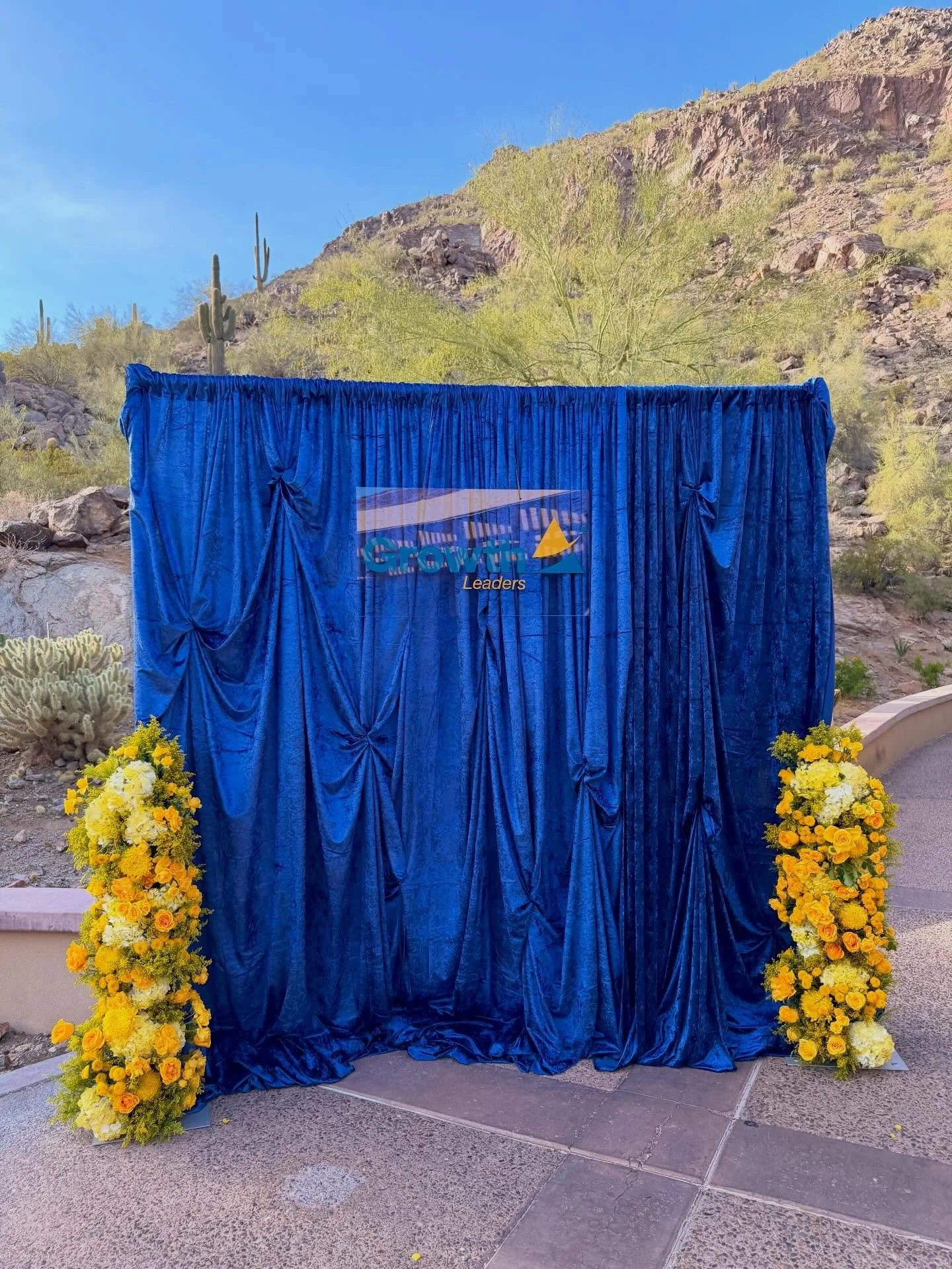 Custom sign + drapery backdrop moment in the Arizona desert ✨🌵
We designed and installed this rich blue drapery setup paired with bold yellow florals and a custom branded sign to create a statement photo moment that truly stands out.

Planning an ev