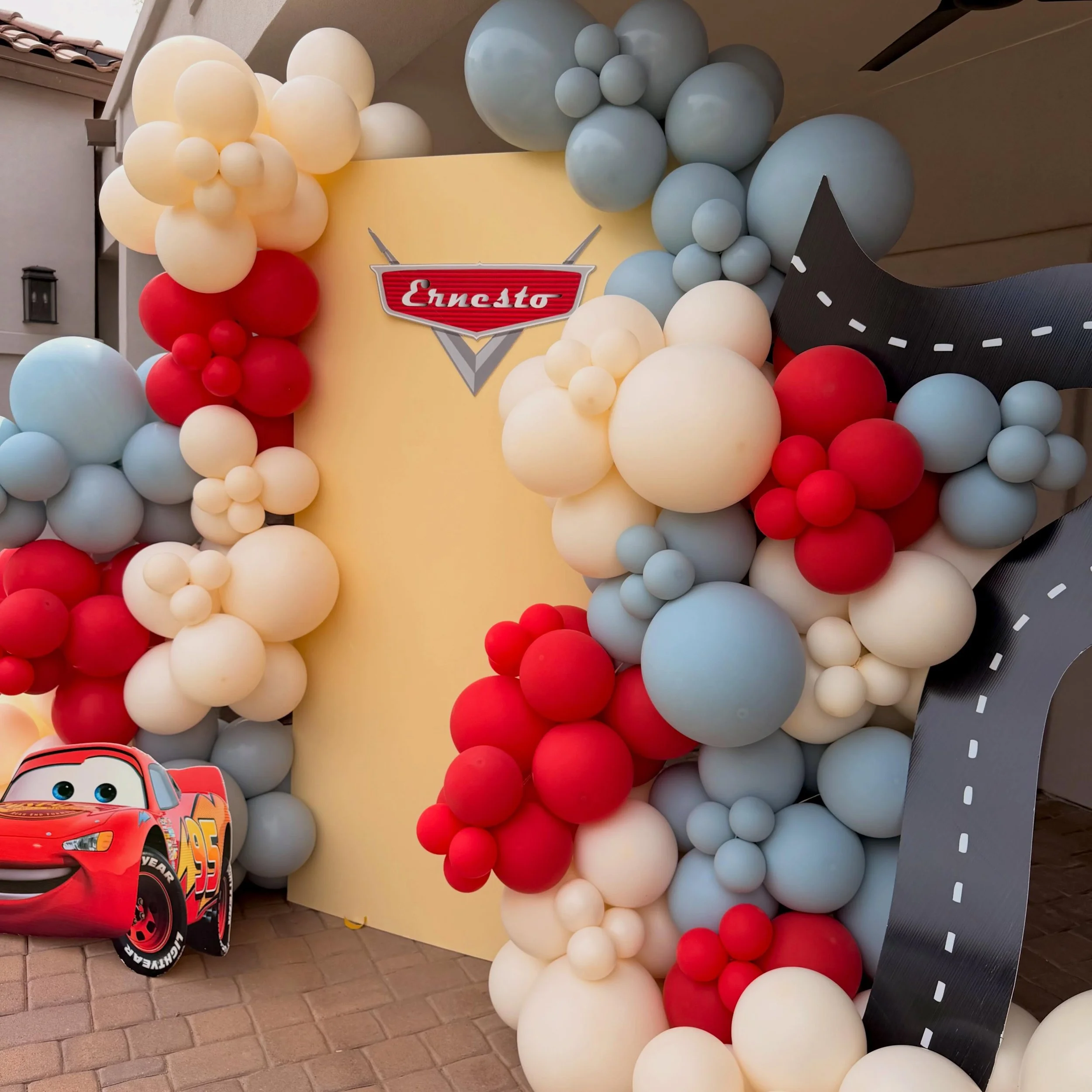 Happy 2nd Birthday Ernesto 🏁❤️

We brought the race track to life with this custom Lightning McQueen themed setup, featuring bold red, soft blue, and creamy neutral balloons layered into our signature full, luxe clusters. From the curved backdrop to