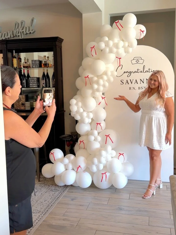 Proud Mom moment🤍🩺 Custom RN BSN backdrop with hand-drawn nurse cap details and an all-white balloon installation for the sweetest setup. From Scottsdale to Phoenix and Mesa, we love creating graduation party decor that feels personal, elevated, an