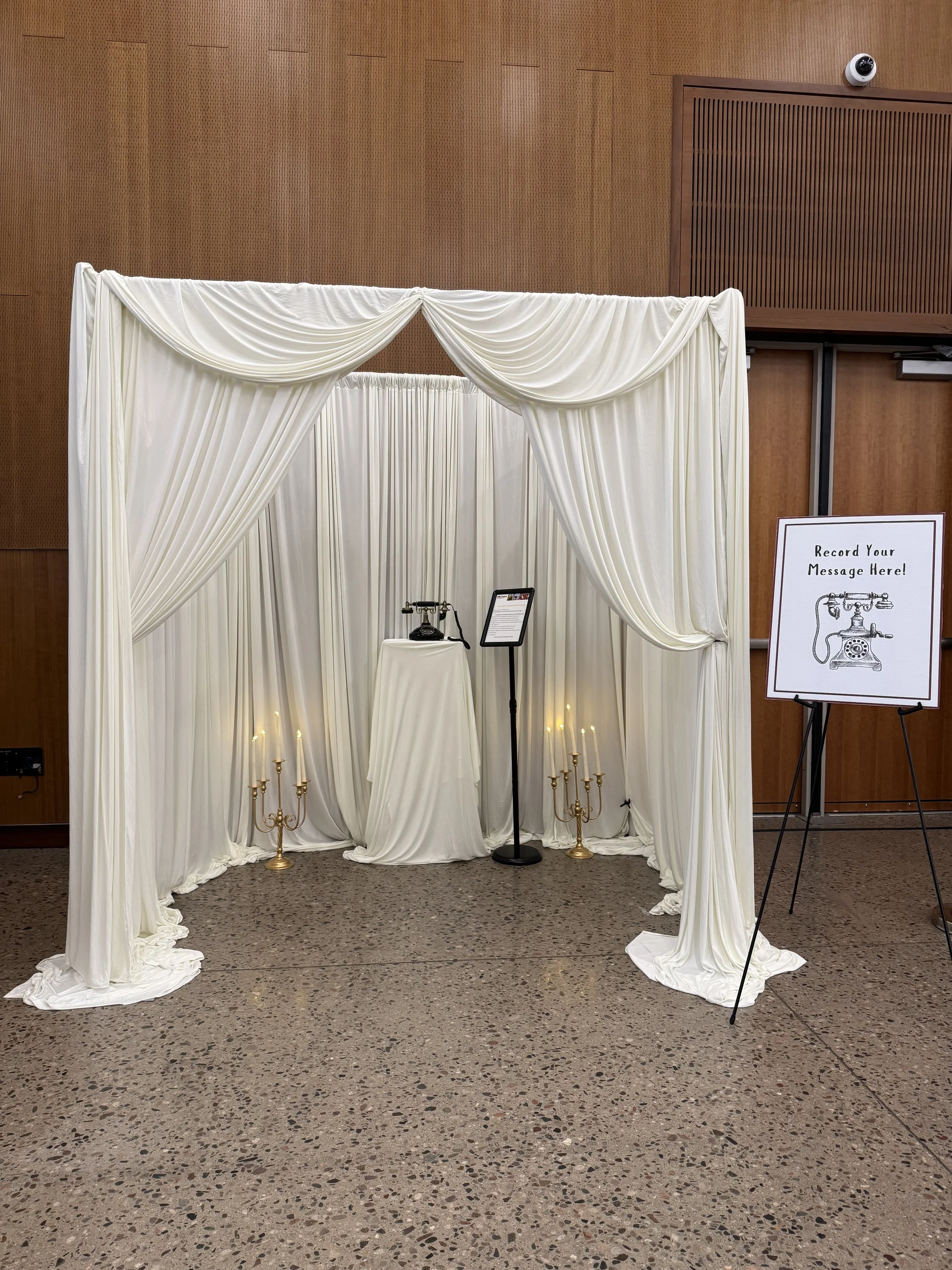 Elegant ivory wedding ceremony backdrop featuring luxurious draped fabric panels, soft candlelight accents, and romantic entrance styling. Custom wedding draping installation designed for a ceremony, reception entrance, or photo backdrop in Phoenix, 