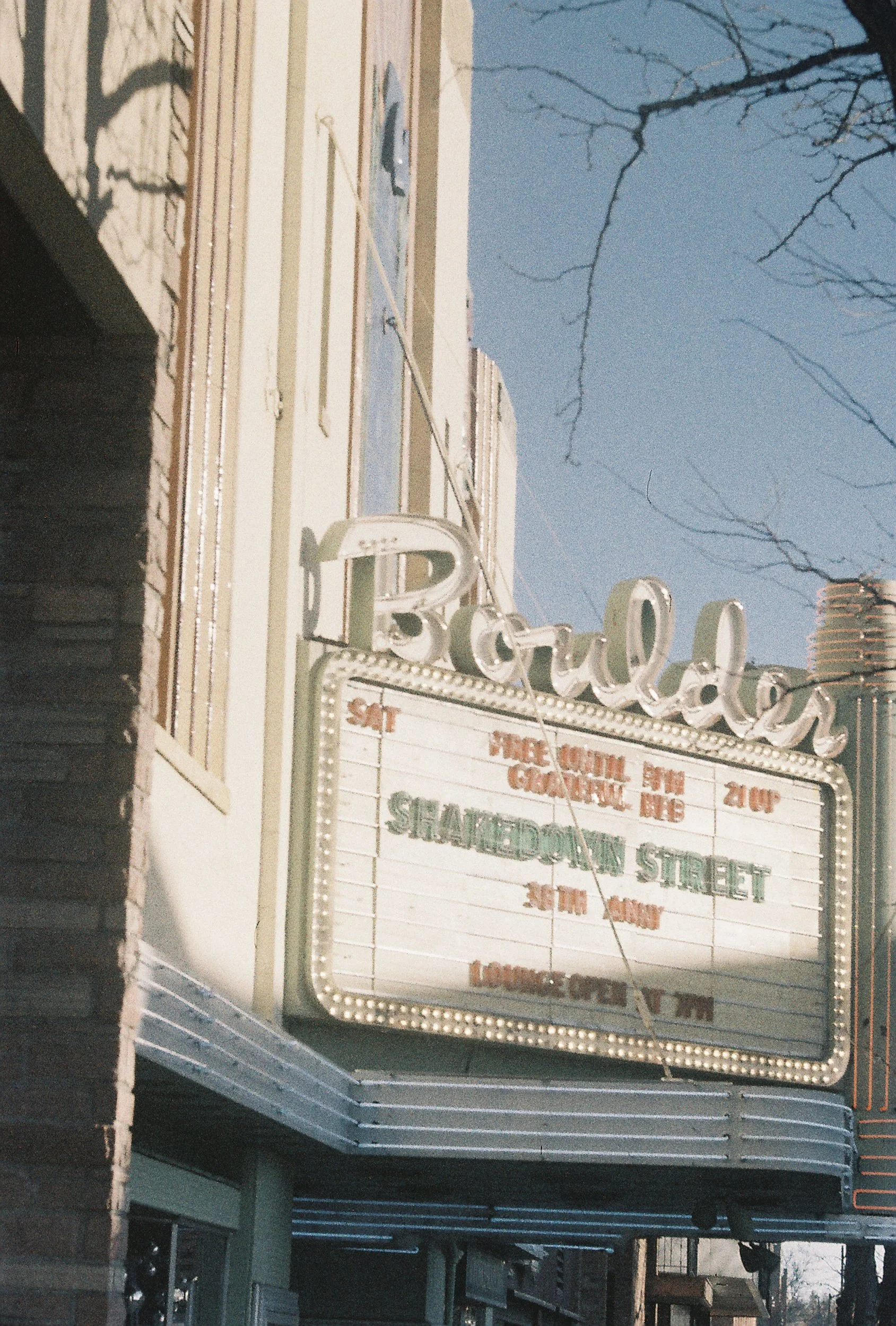 A vintage theater marquee with illuminated borders, advertising a show with a list of acts and features, including 'Fire Volume' and 'Granny'.