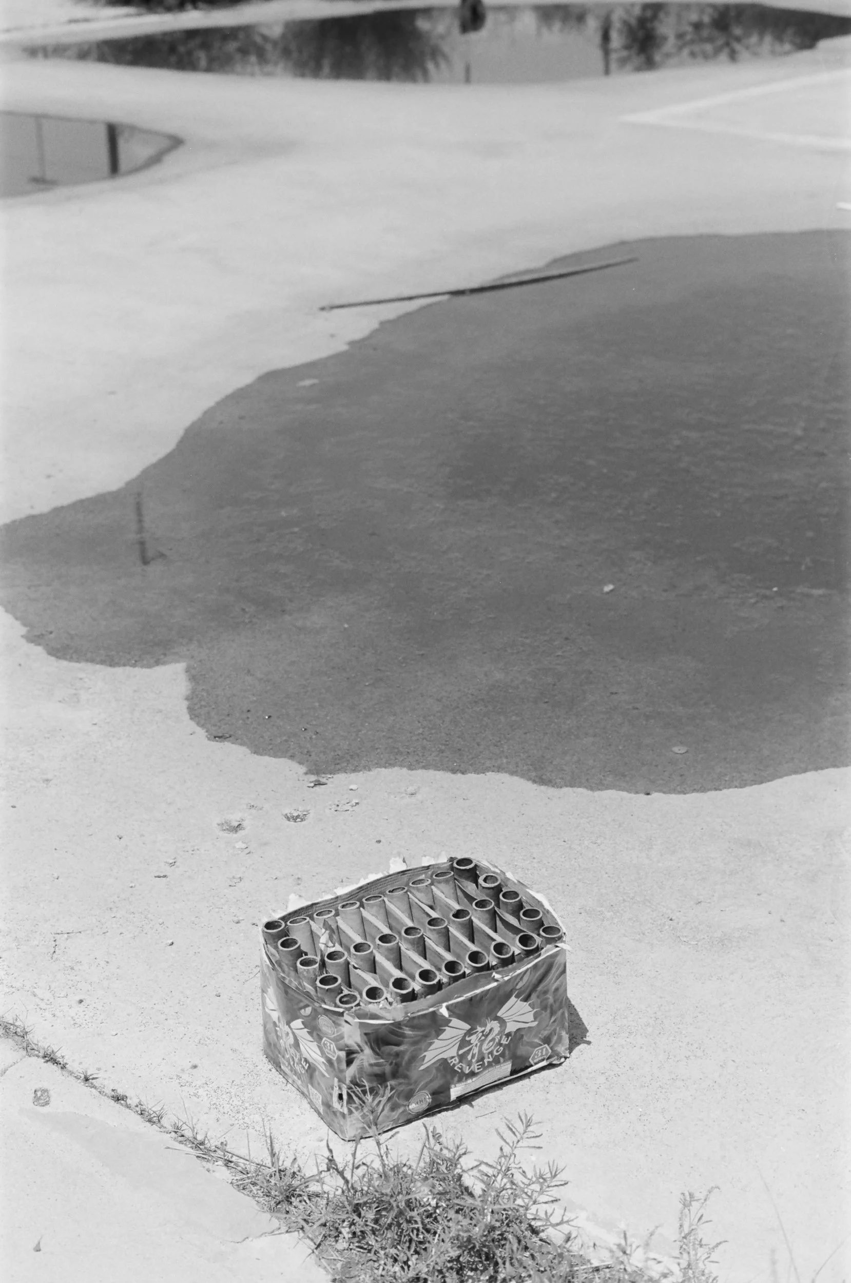 A box of fireworks on the snow with a gap in the snow revealing the ground below.