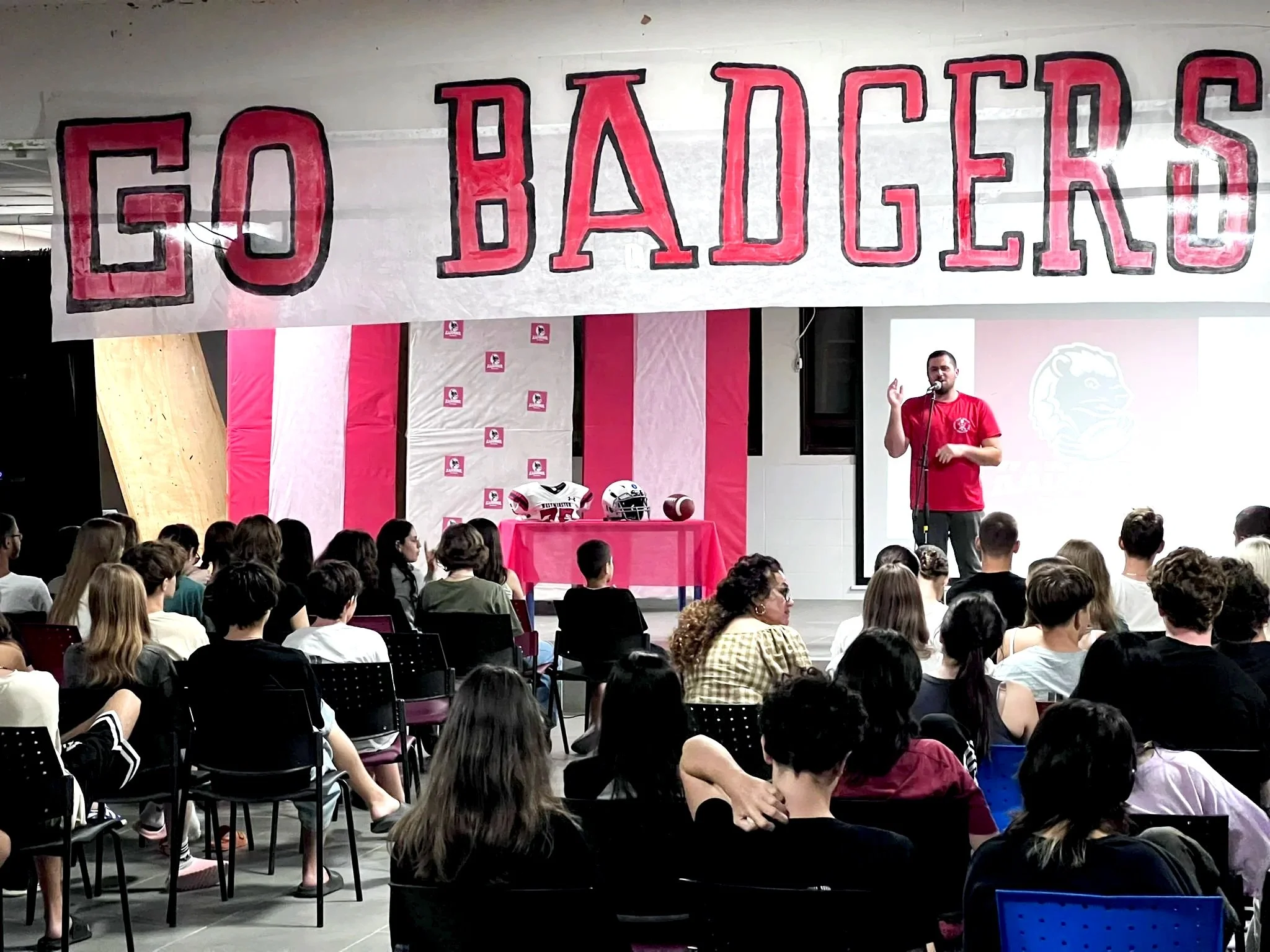 Kadoorie football team event, with a large banner that says 'GO BADGERS' hanging above.