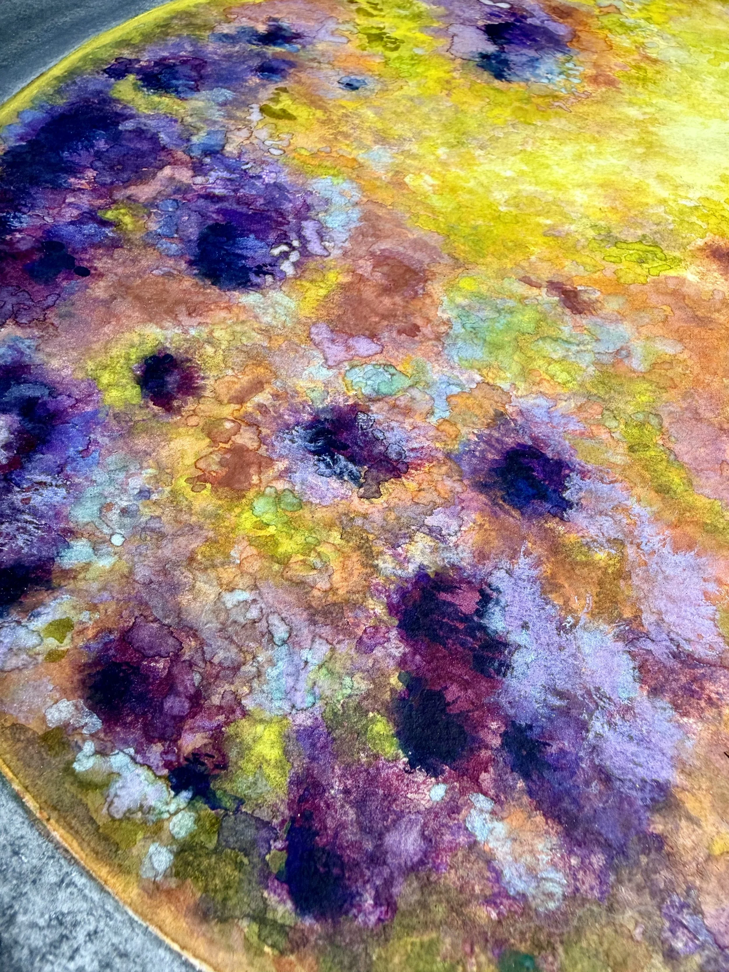 An abstract watercolor painting with vibrant swirls of purple, yellow, green, pink, and blue, creating a textured and colorful composition.