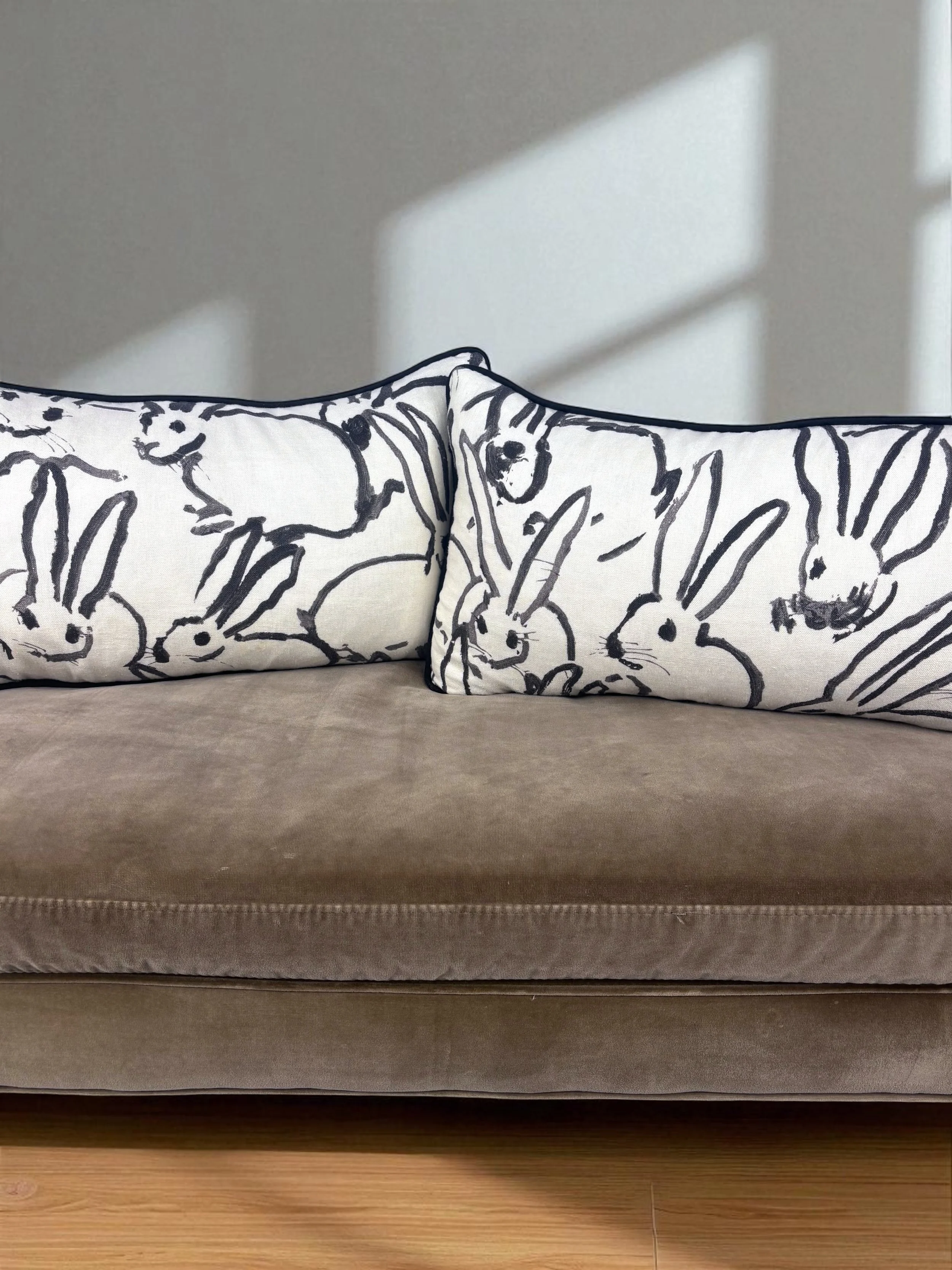 Image of handmade lumbar pillows, featuring a gorgeous black and white rabbit design by artist Hunt Slonem.