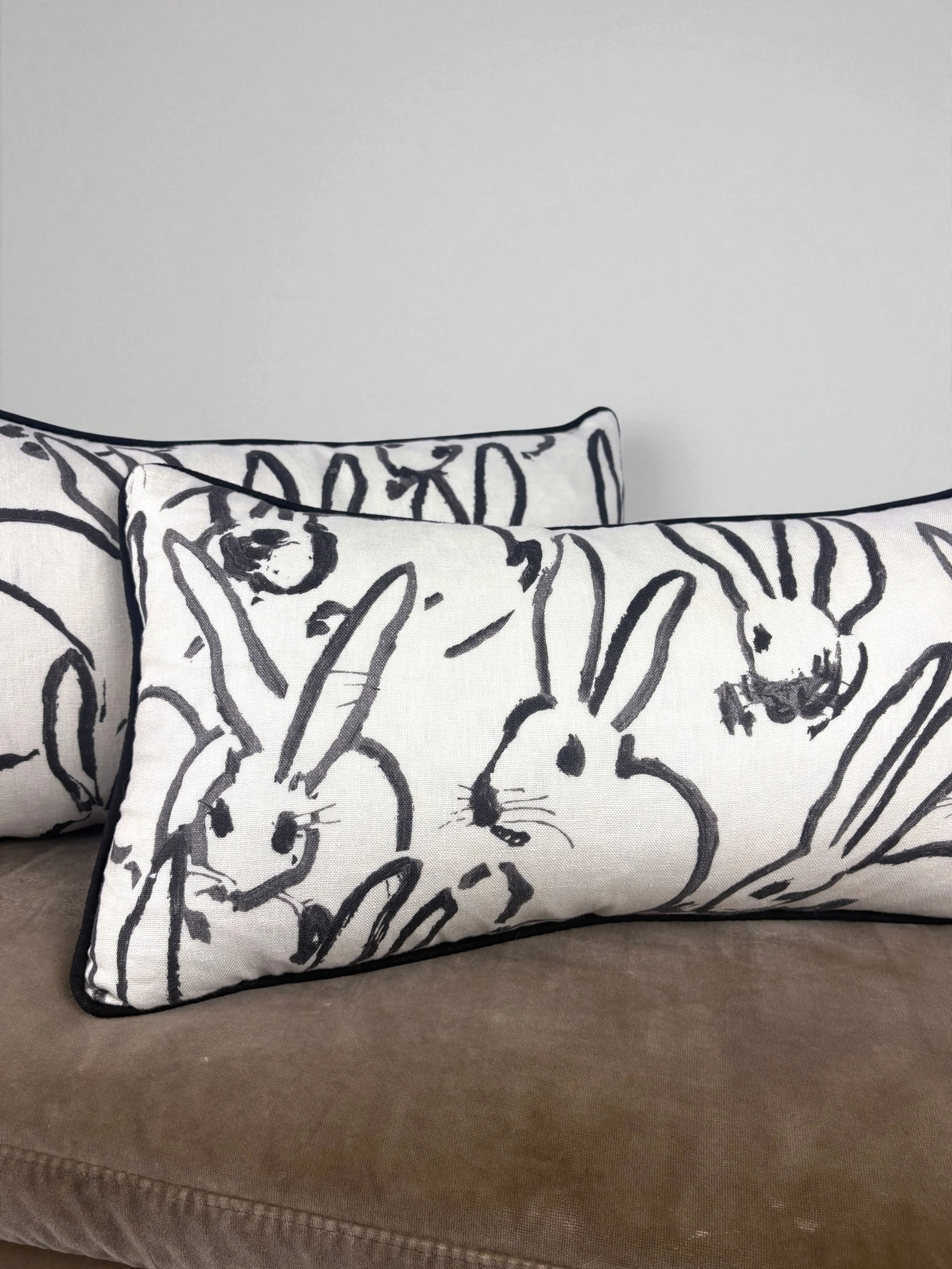 Image of handmade lumbar pillows, featuring a gorgeous black and white rabbit design by artist Hunt Slonem.