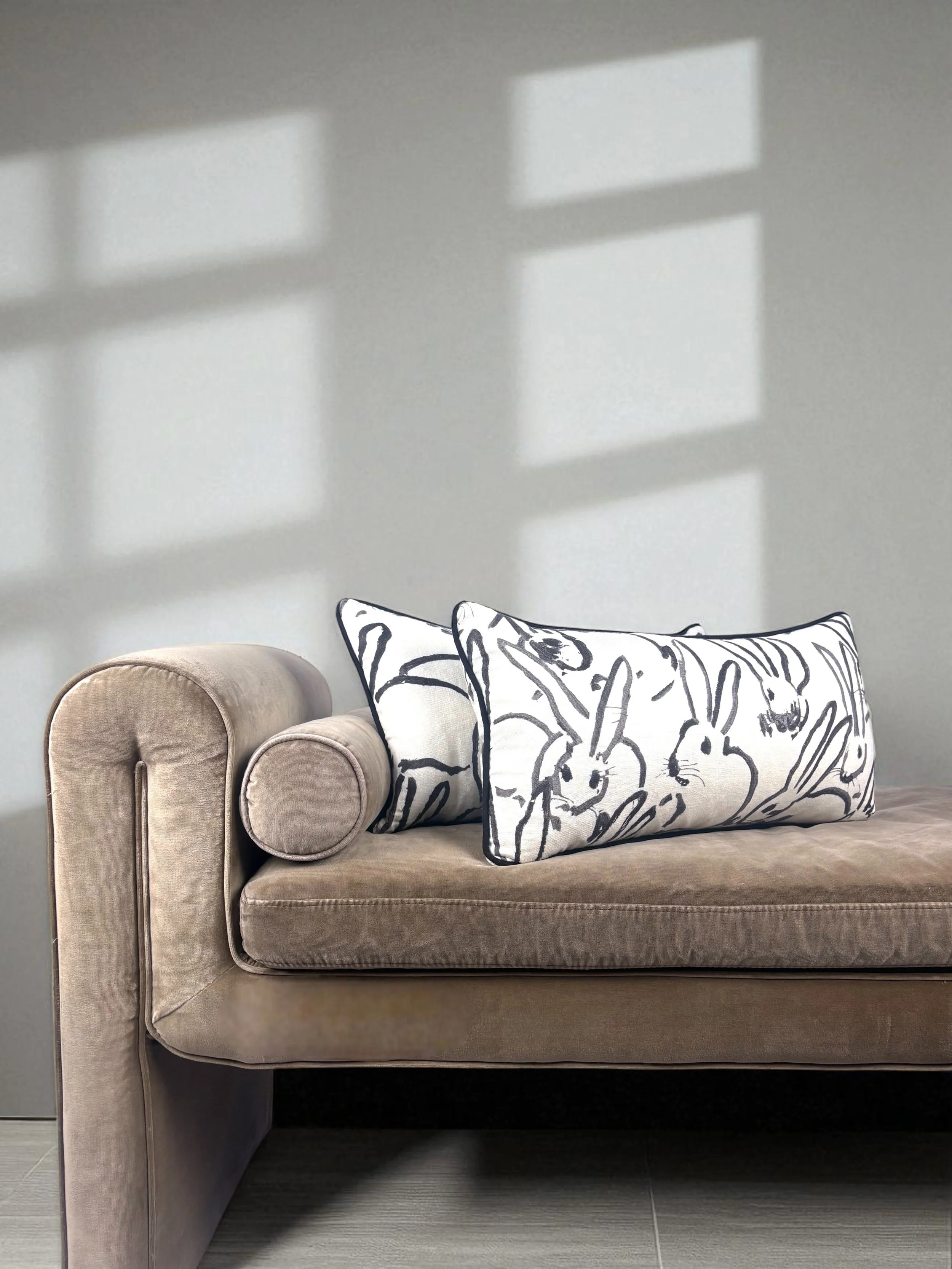 Image of handmade lumbar pillows, featuring a gorgeous black and white rabbit design by artist Hunt Slonem.