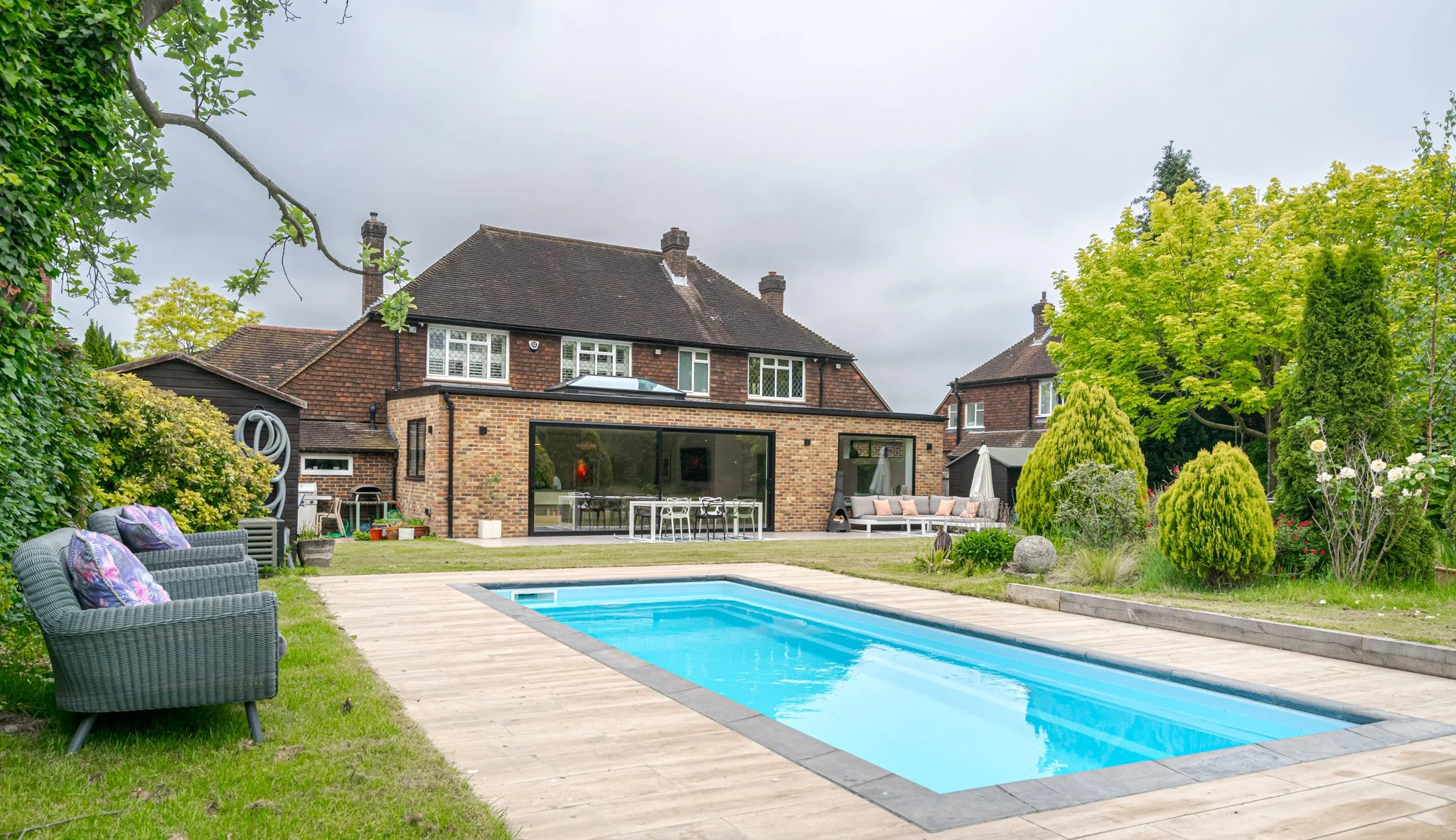 Lawn House - Bromley - Photoshoot and filming location. A large modern family house with huge open-plan kitchen. The garden features a vast lush lawn, dining terrace, outdoor pool, Wendy House, trampoline, hammock and outdoor seating. Inside boasts c