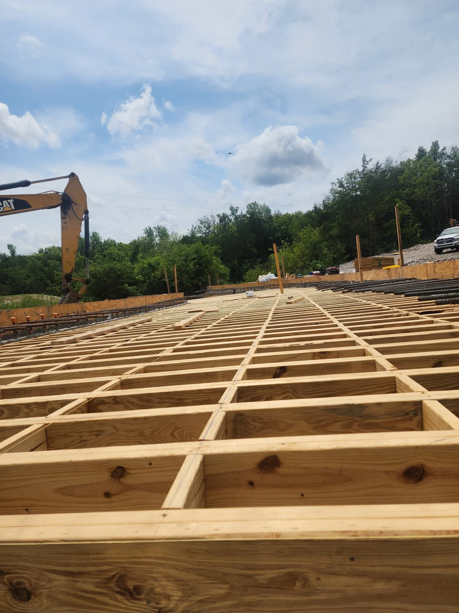 Construction site with wooden framing and clear sky.