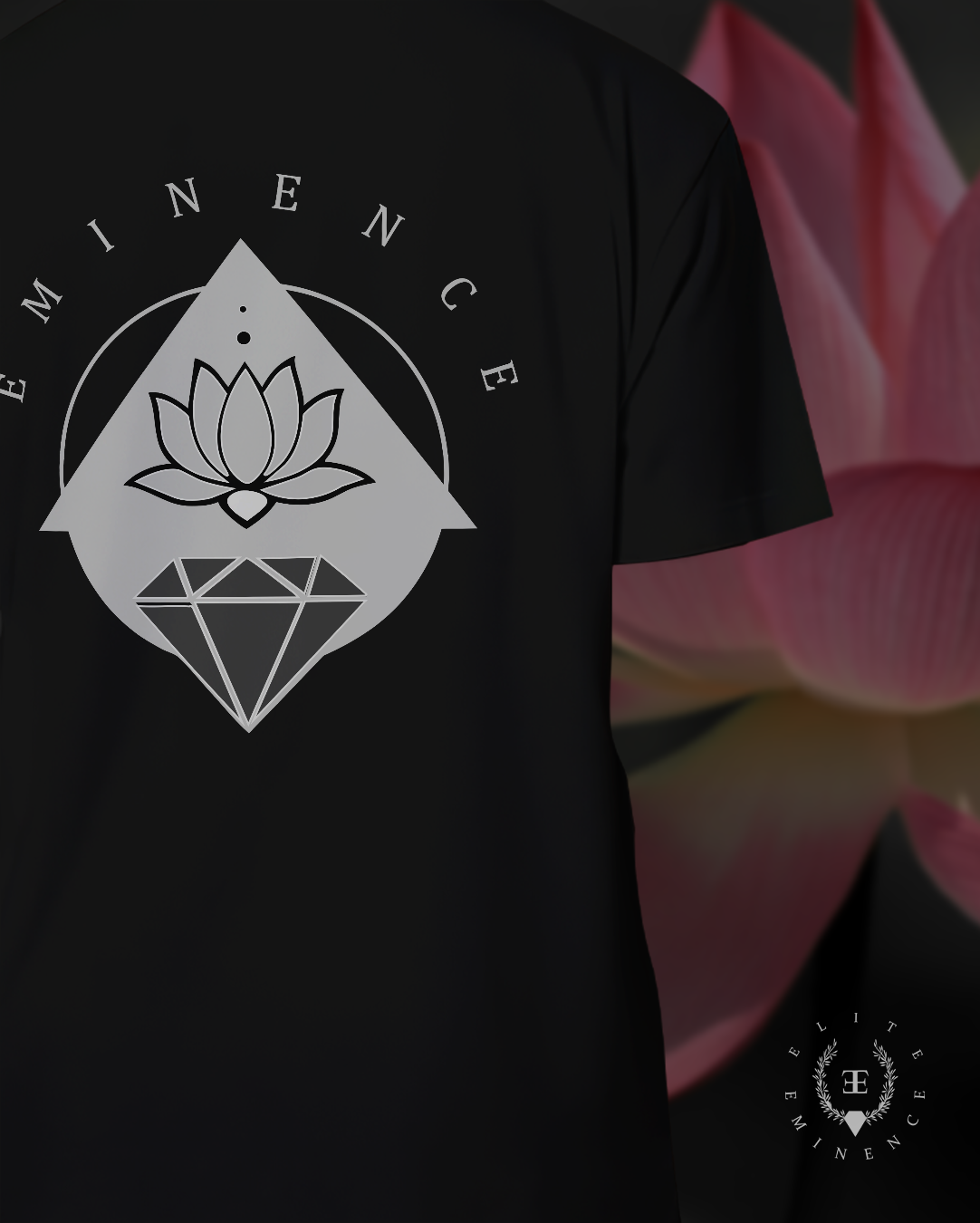 Black t-shirt with a white logo featuring a lotus flower above a diamond shape, the words 'EMINENCE' arching above, and a smaller circular emblem with a 'T' and the words 'LITTLE EMINENCE' in the lower right corner.