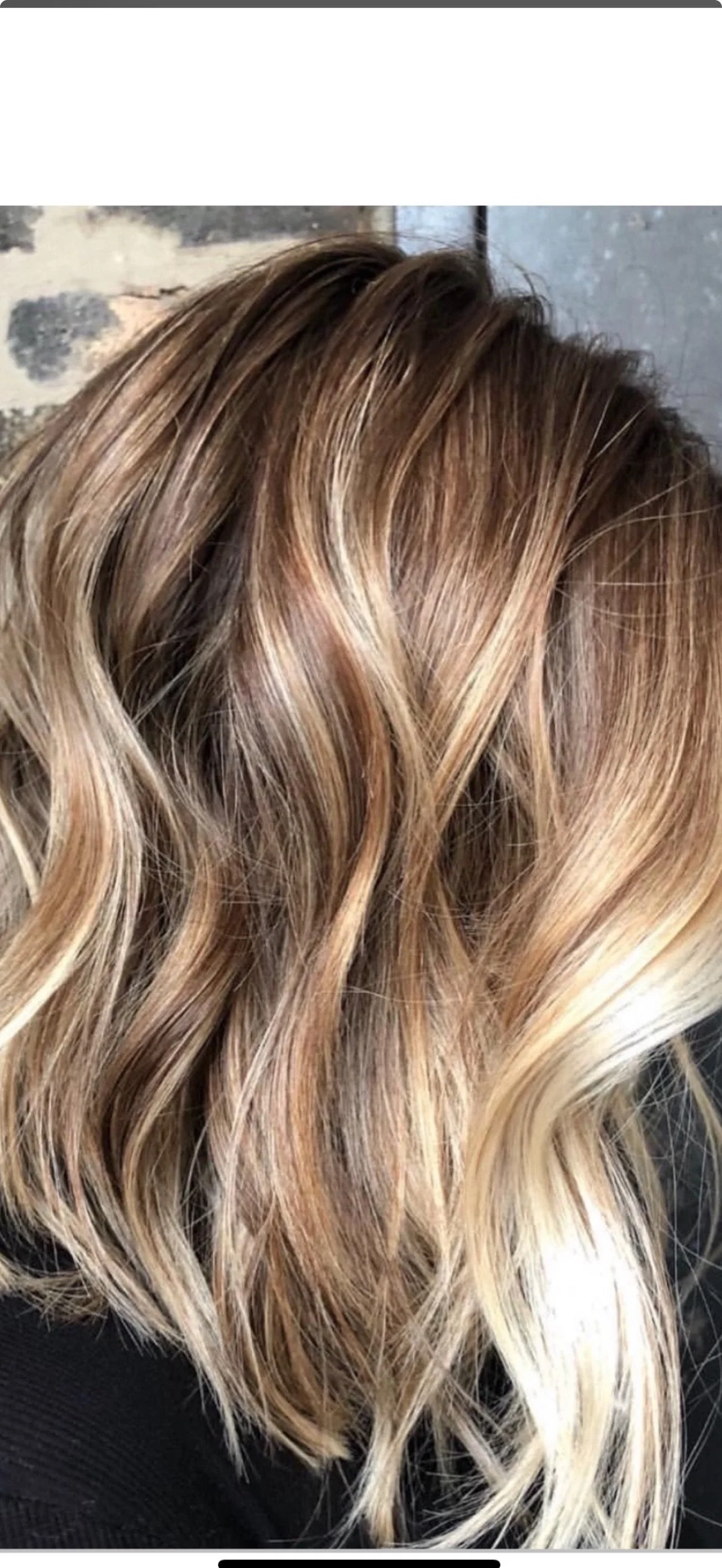 Close-up of wavy blonde hair with highlights.