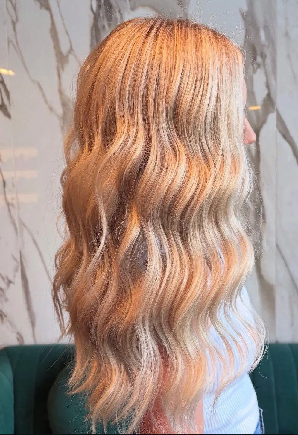 Side view of a woman with long, wavy, blonde hair.