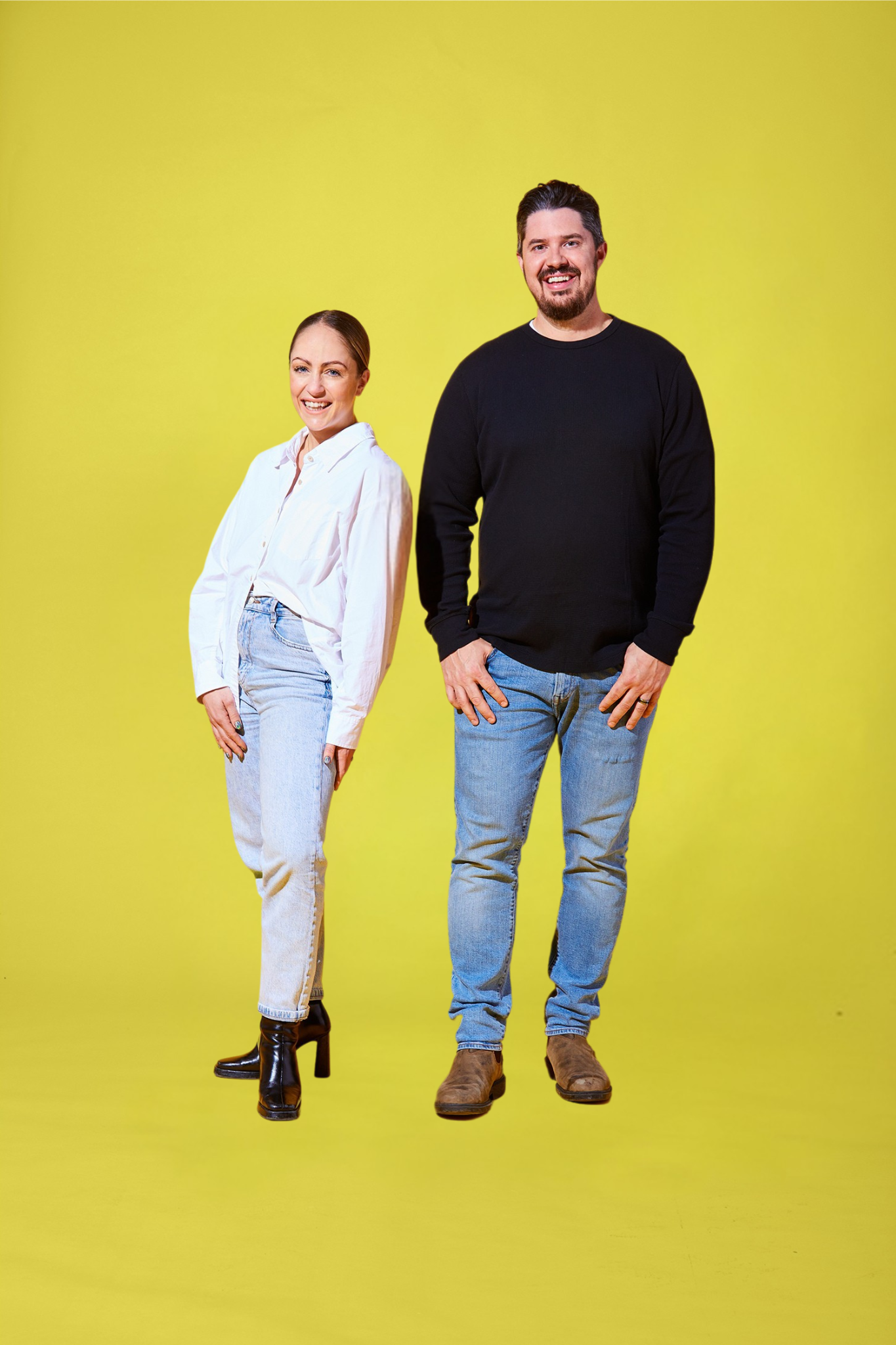 Samantha and Grant Buckley standing side by side against a yellow background, smiling.