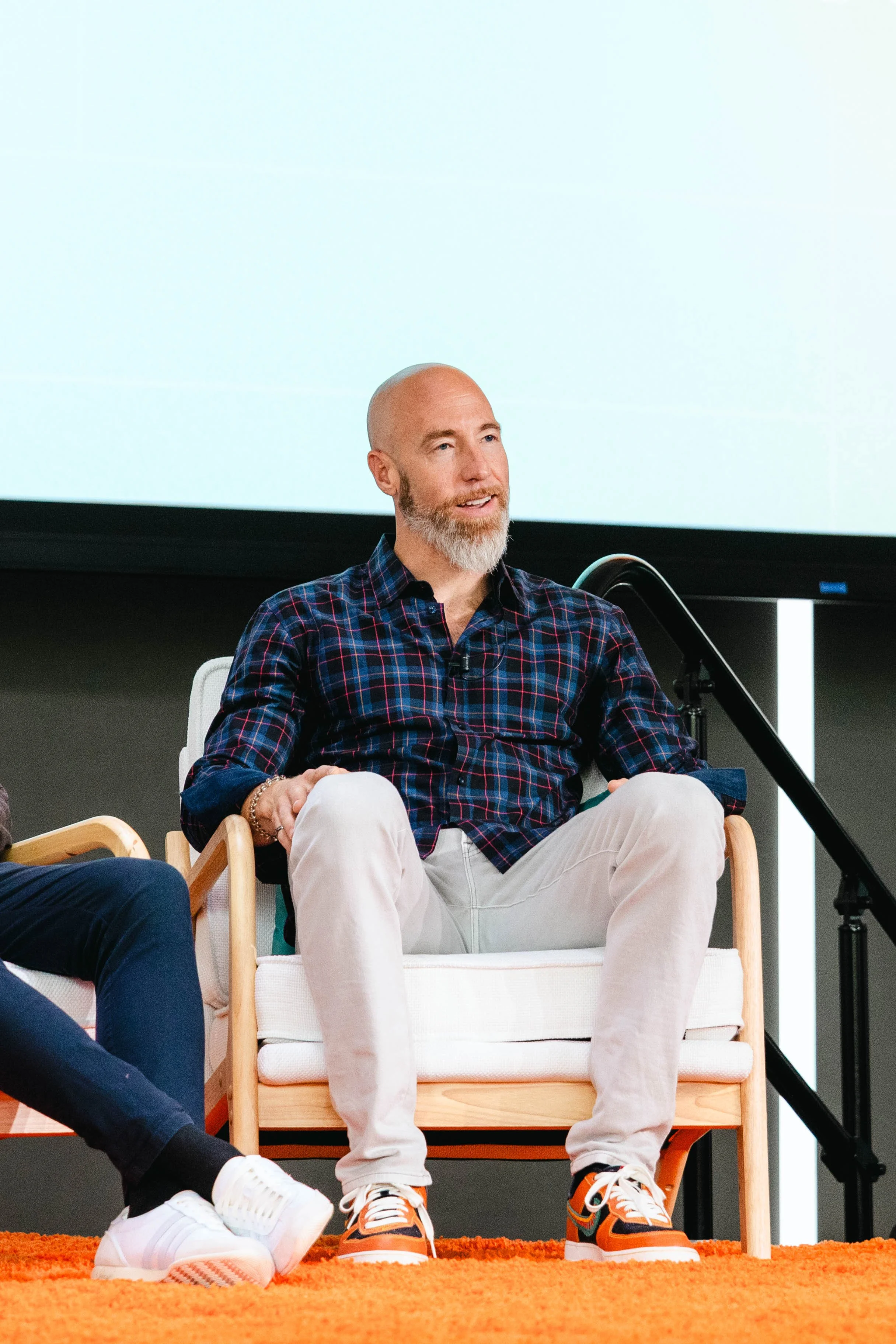 Jared Harding, Athlete Brand Coach and founder of Tewdilly, speaking on a panel seated on stage in a plaid shirt.