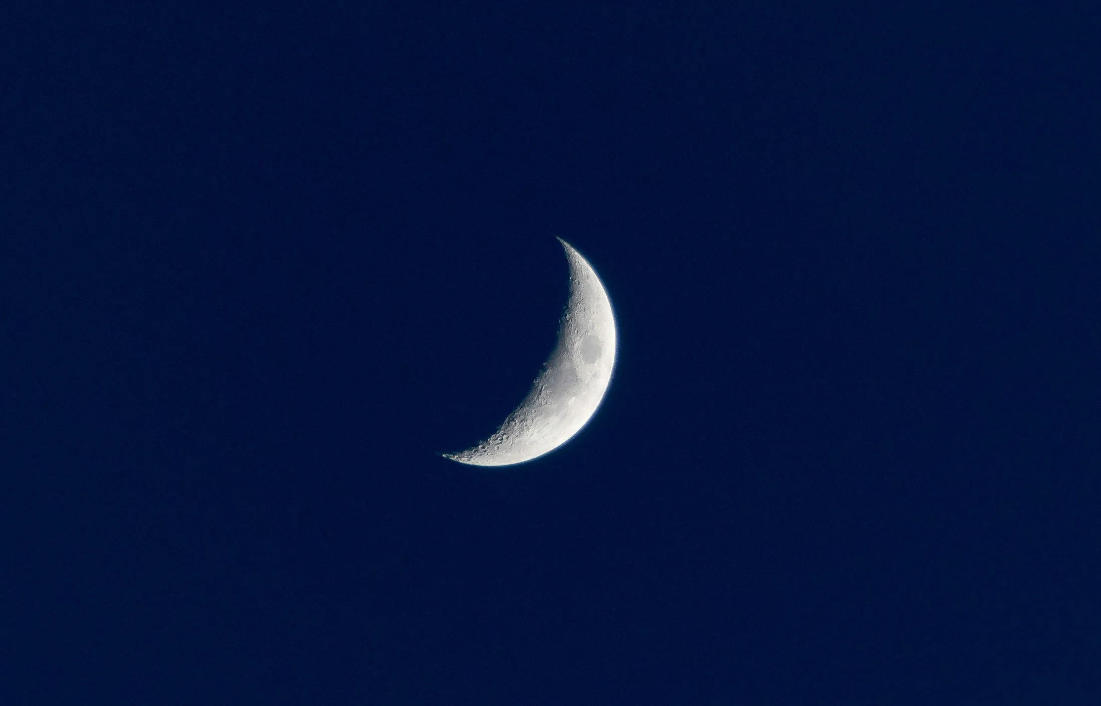 La lune en croissant dans un ciel nocturne clair.