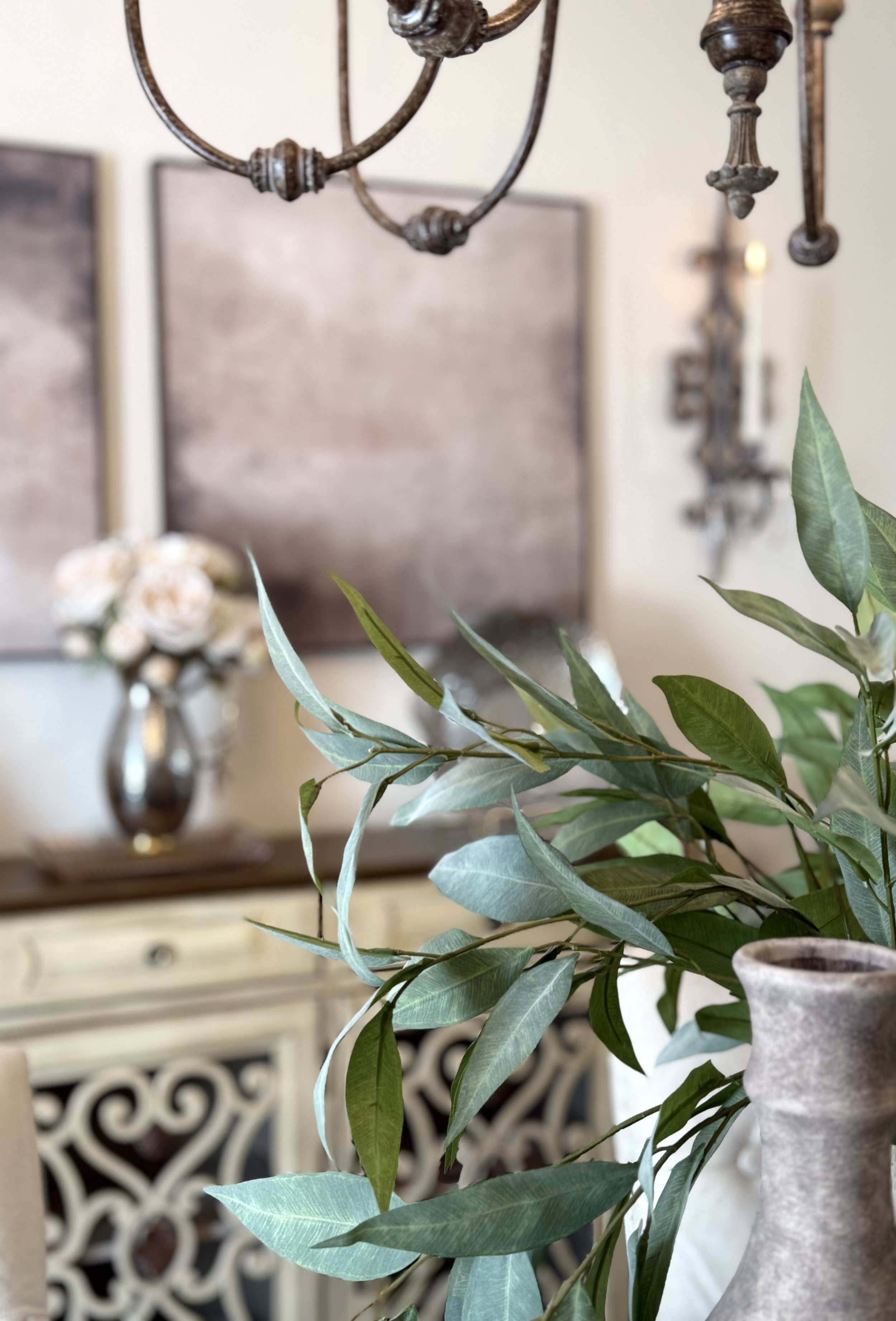 anstract art with pottery and greens with soft pink flowers.