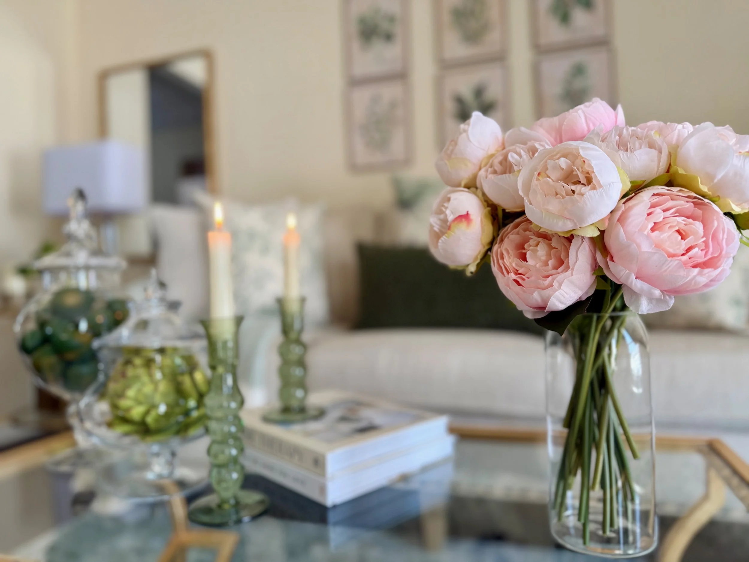This soft pink floral arrangement beautifully compliments this sage green and white living room.