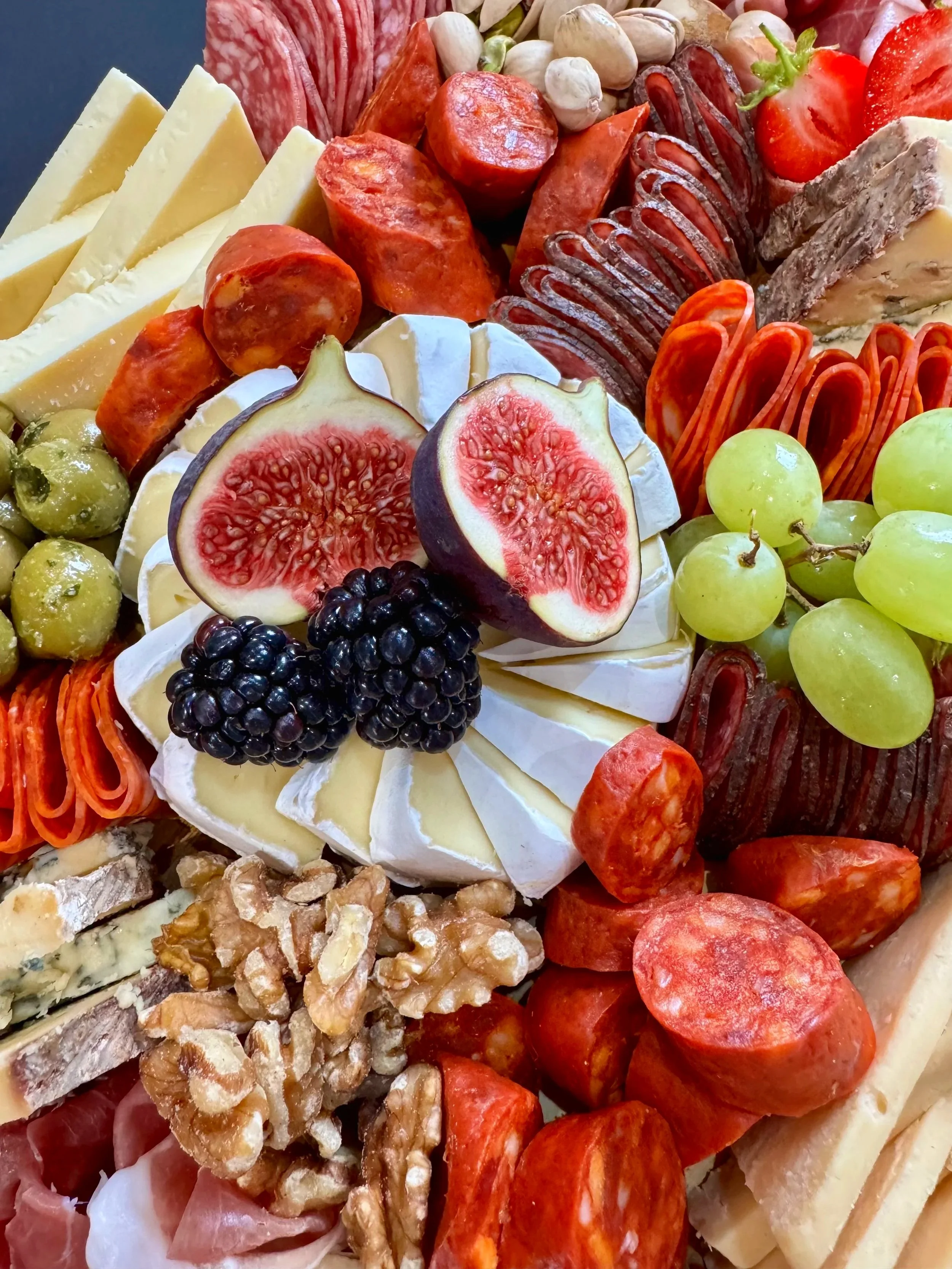 Top-down view of a luxury grazing platter for 6–8, featuring artisan cheeses, charcuterie, crackers, fruits, nuts, and dips, artfully arranged.