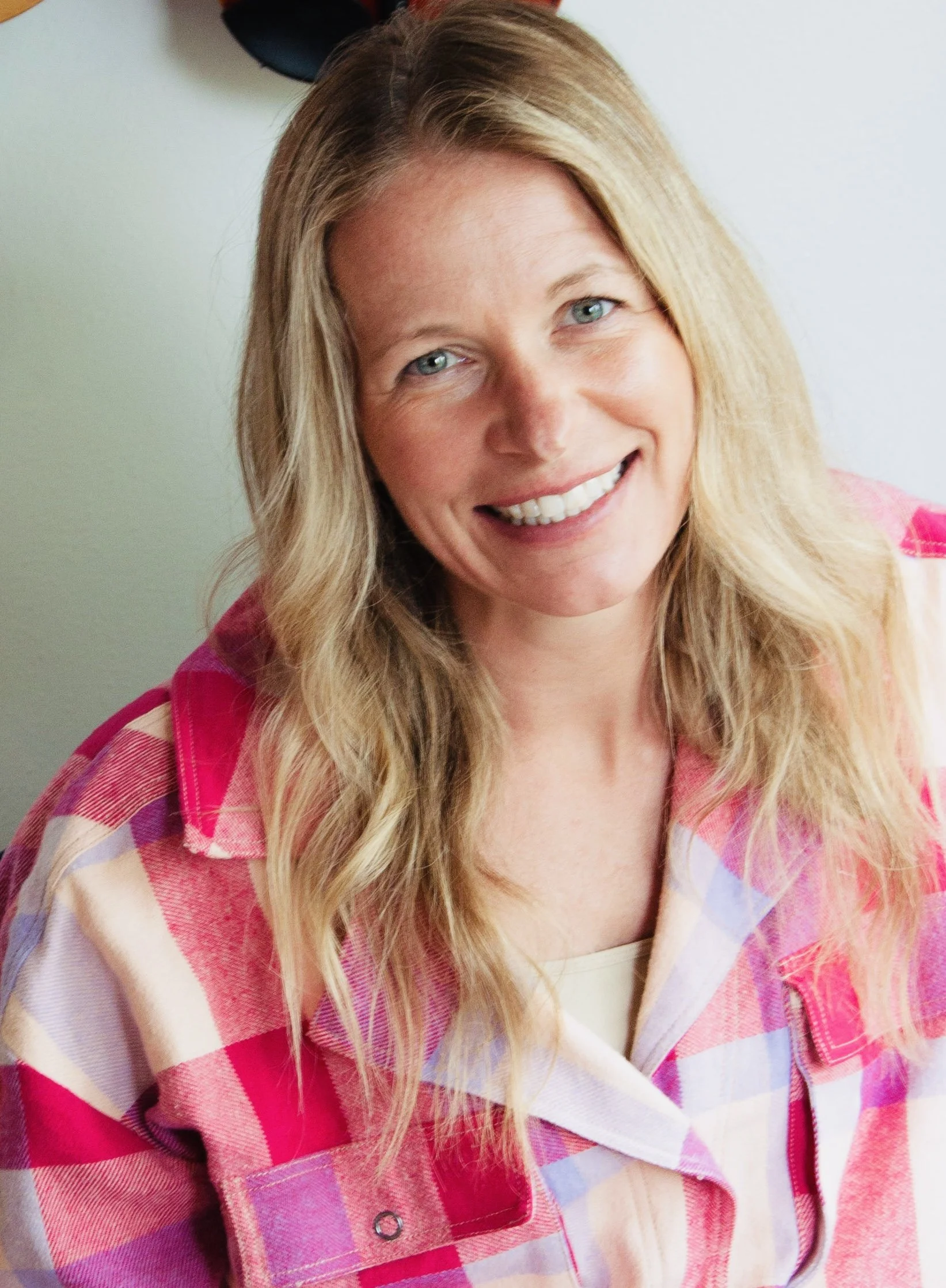 Smiling woman with blonde hair and a pink shirt