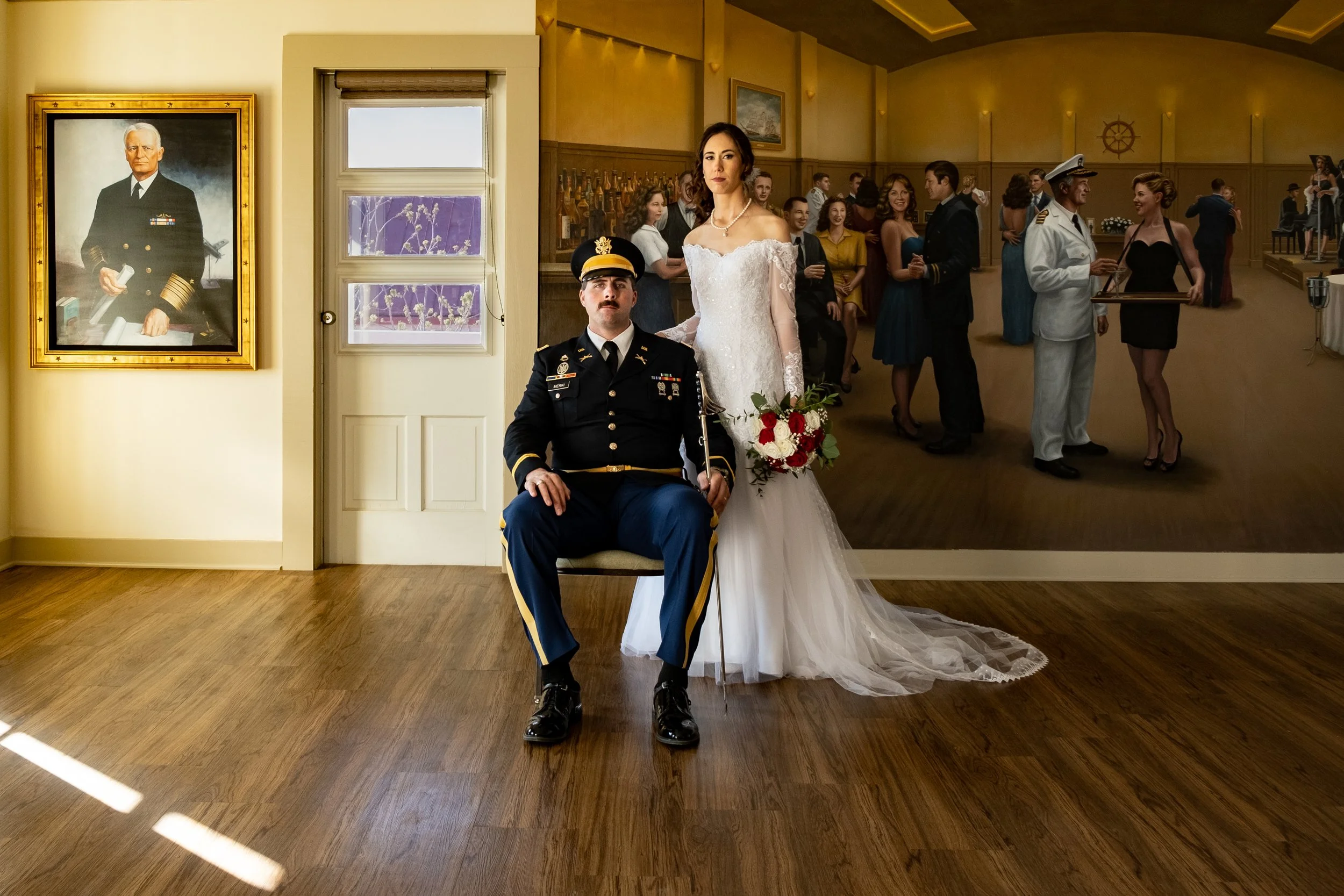 A wedding scene with a bride in a white dress, a man in a military uniform seated in front, and guests in formal attire in the background at an indoor venue.