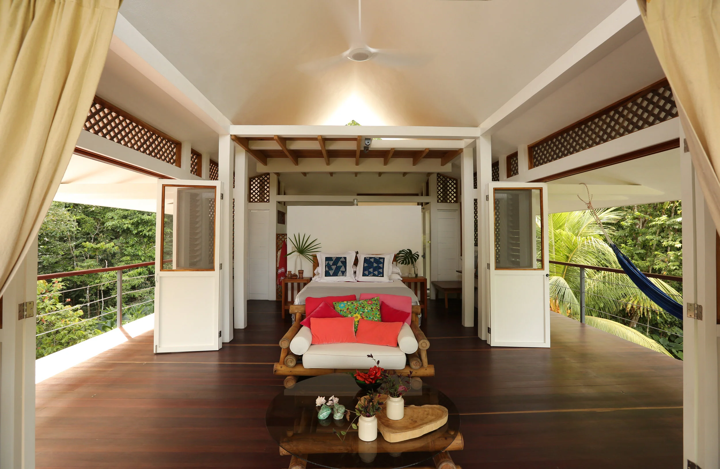 Bright, spacious room with curtains pulled back, a hammock outside on the balcony, and natural light filling the space.”