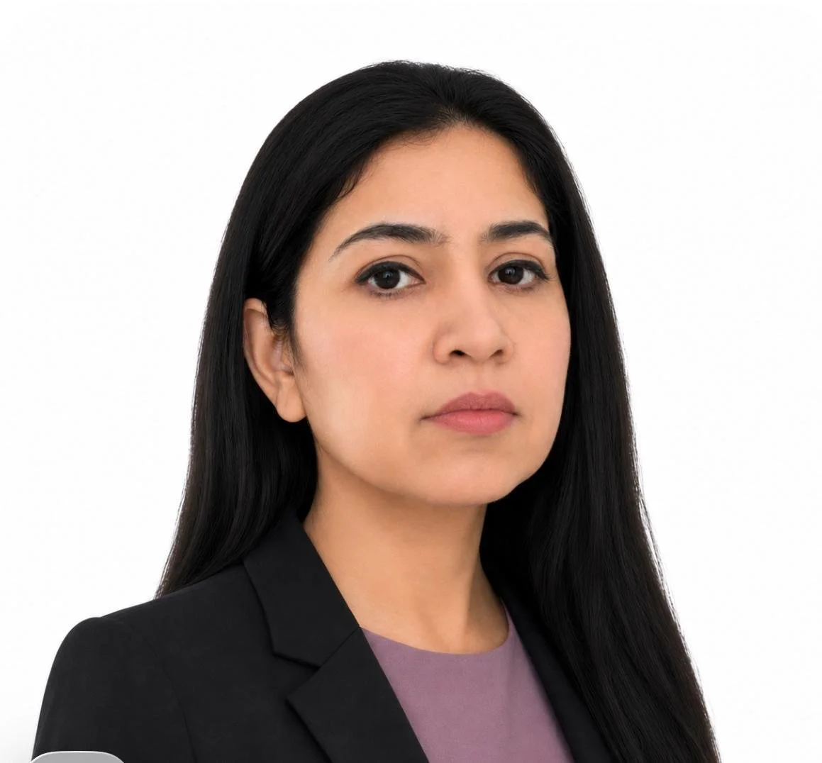Headshot of a woman with long black hair wearing a black blazer and purple top against a white background.