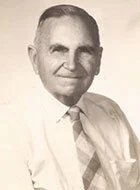 Black and white portrait of Bruno Tapiolas Vila in a white shirt and a striped tie