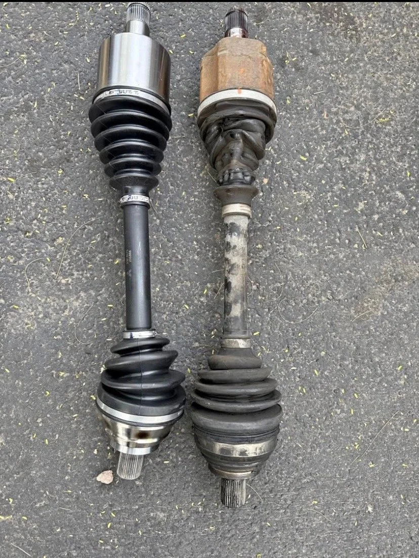 Comparison of a new, clean automotive CV axle on the left and a worn, dirty CV axle on the right.