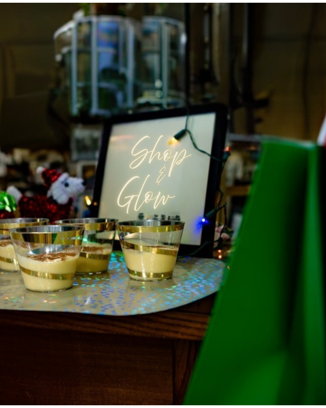 Decorative dessert cups on a table, a sign that says 'Shop & Glow', and holiday-themed decor in the background.