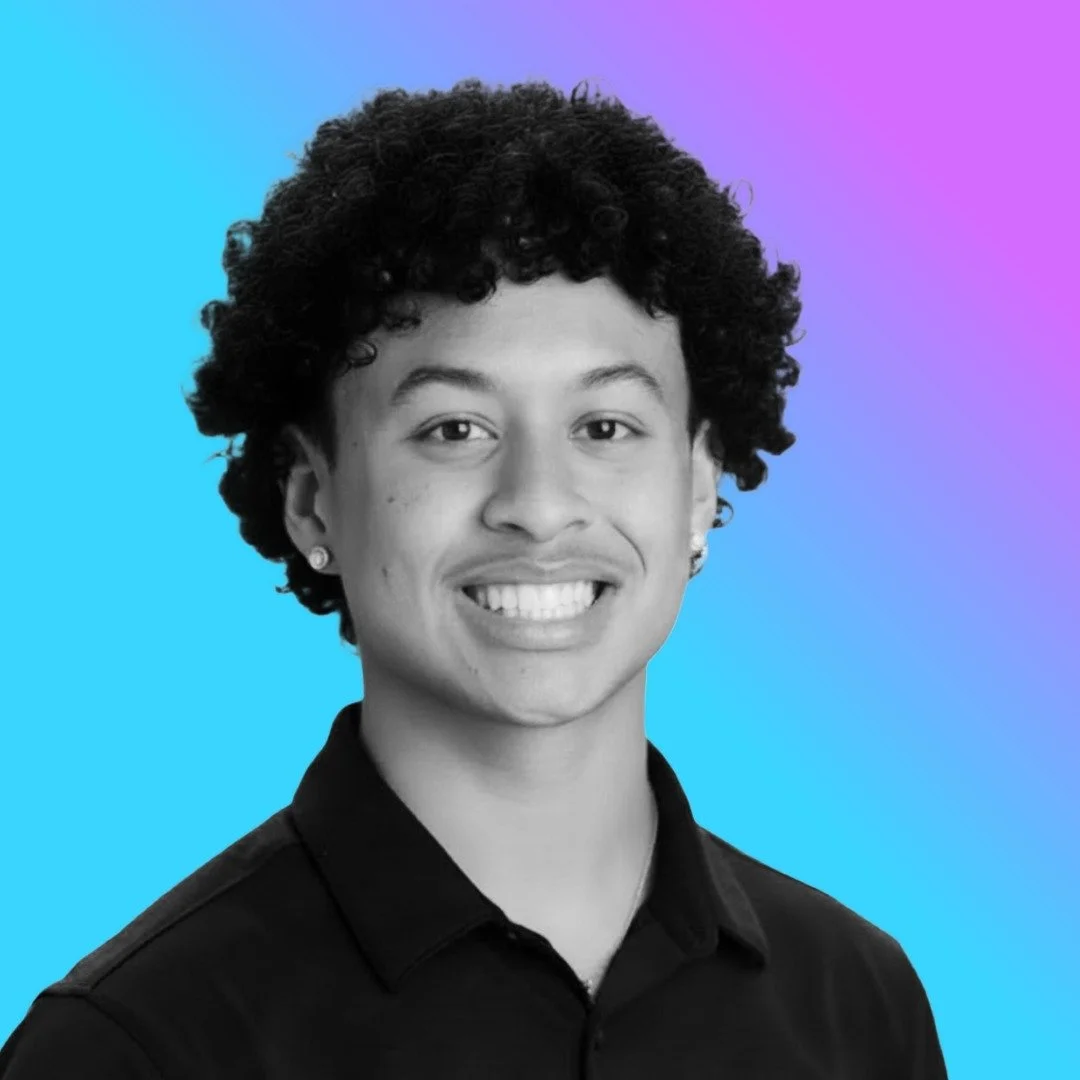 Black and white portrait of a smiling person with curly hair, earrings, wearing a dark shirt, against a colorful gradient background.