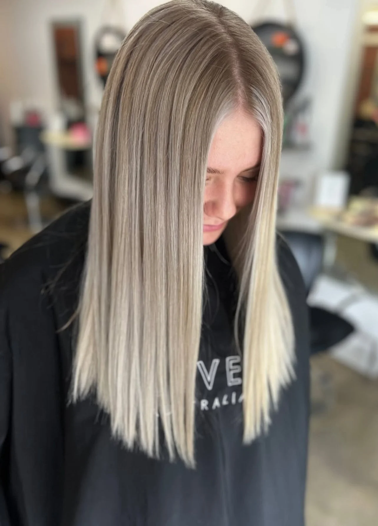 Woman with straight, blonde hair in a salon.