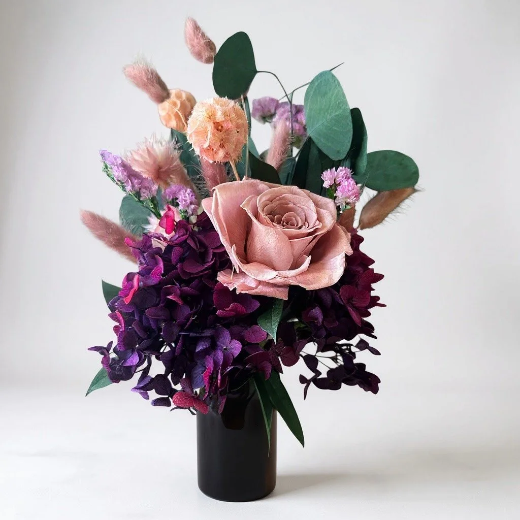 Little Sienne dried arrangement with blush preserved rose and merlot hydrangea in an amber vase