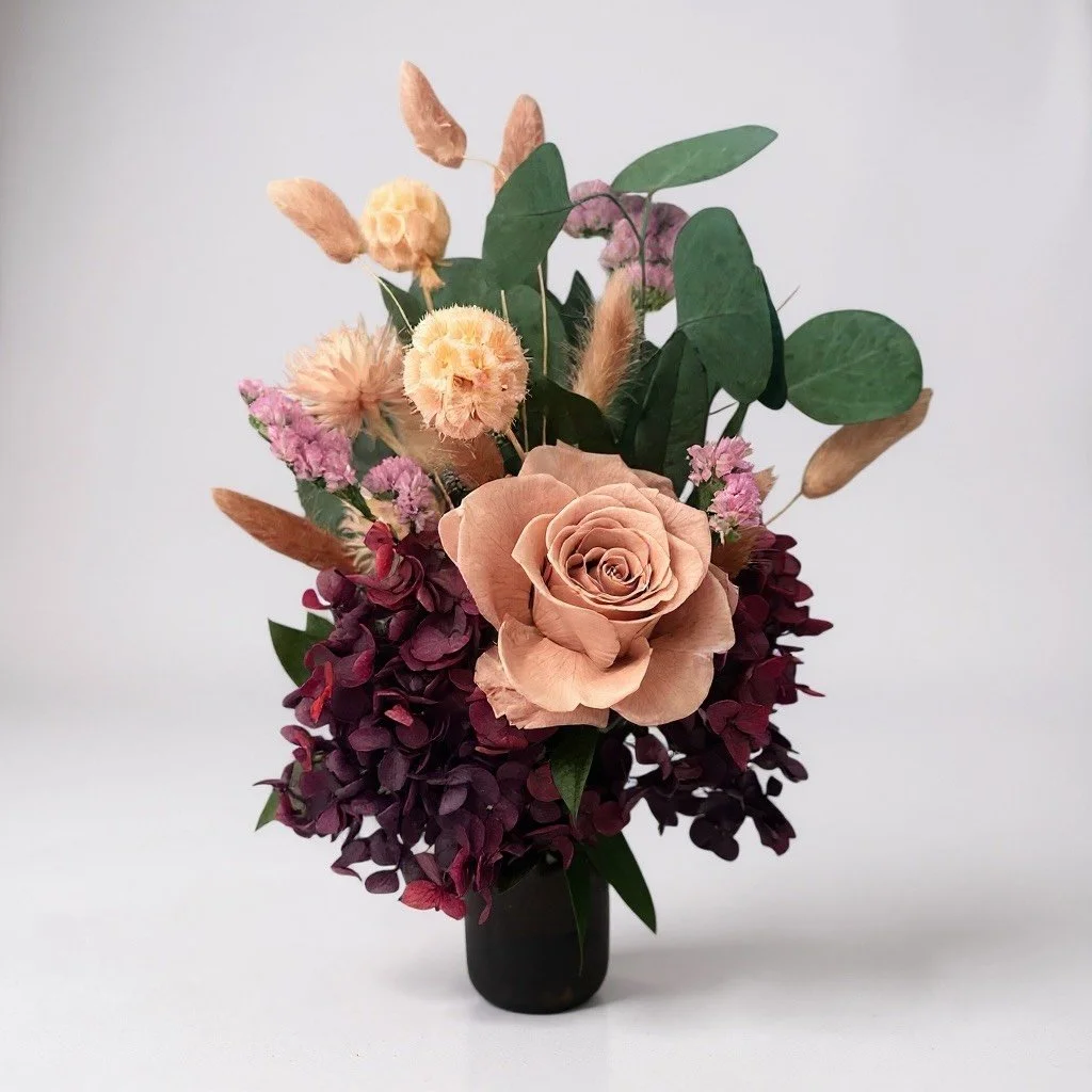 Little Sienne dried arrangement with blush preserved rose and merlot hydrangea in an amber vase