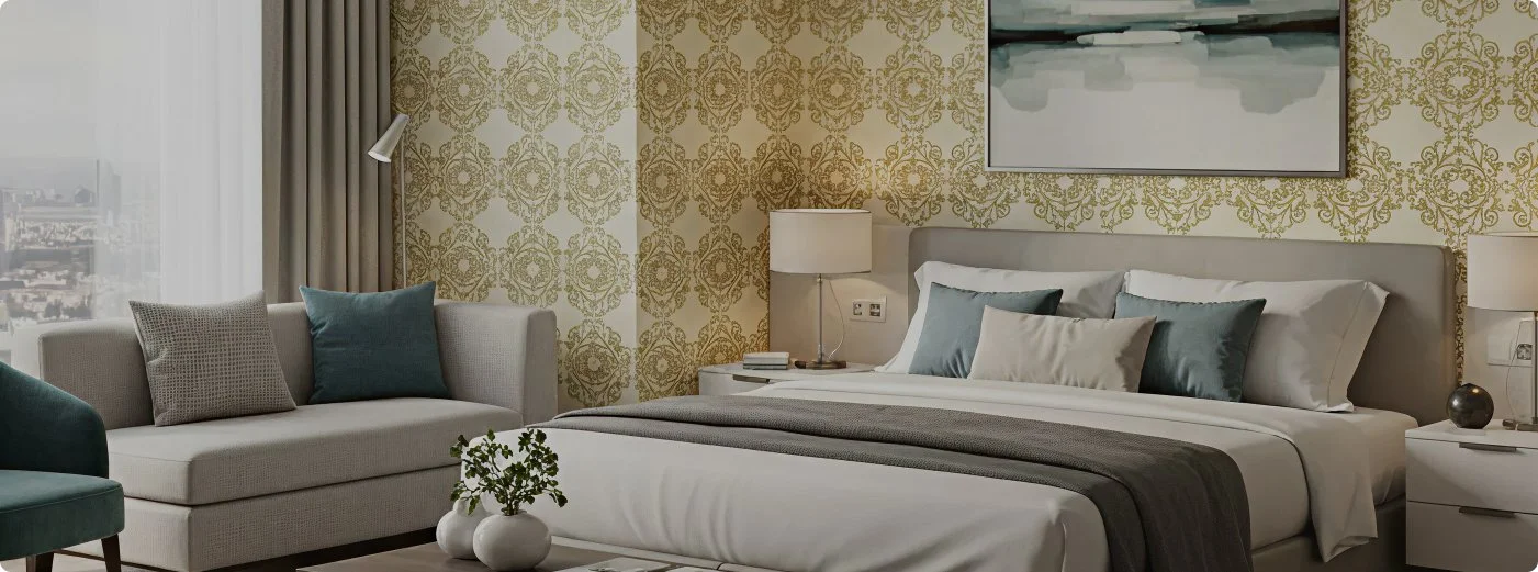 A modern hotel bedroom with a large bed, decorative pillows, a side table with a lamp, a beige sofa with pillows, and a window with curtains. An abstract painting hangs above the bed.