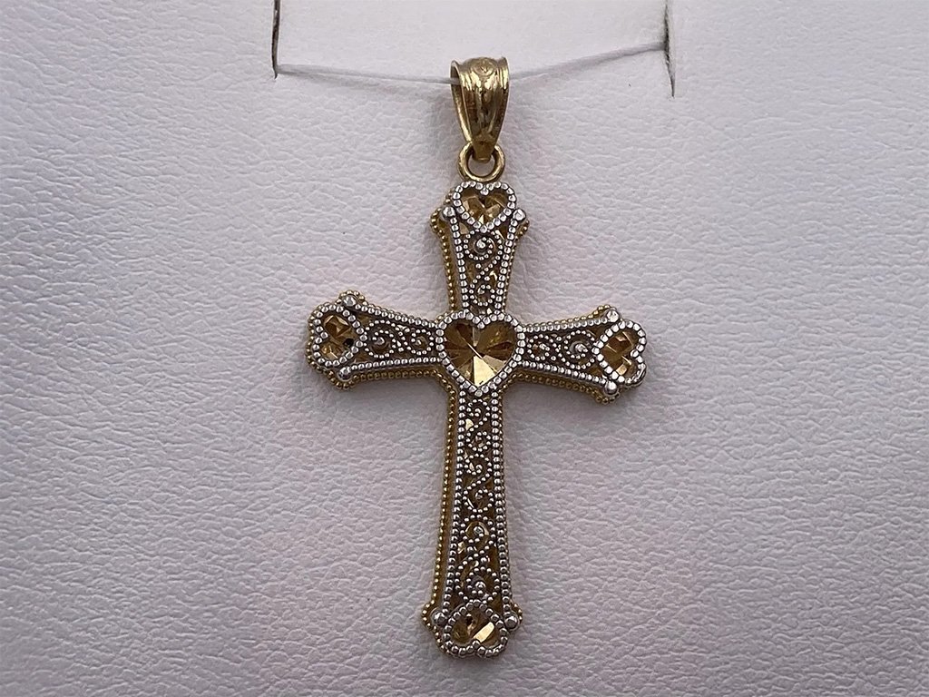 Gold cross pendant with ornate design and small gemstones