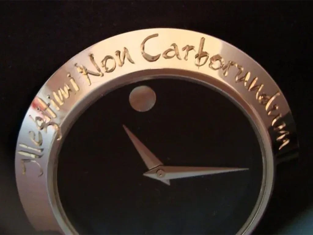A clock with a dark face and silver rim. The rim is engraved with the phrase 'The future is not what it used to be.' The clock hands show the time as approximately 4:25.