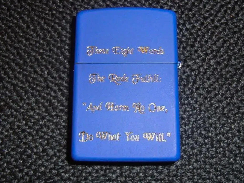 A blue lighter with silver embossed text stating, "Those Eight Words The Regret Fulfill: 'And Cham No One, Do What You Will.'"
