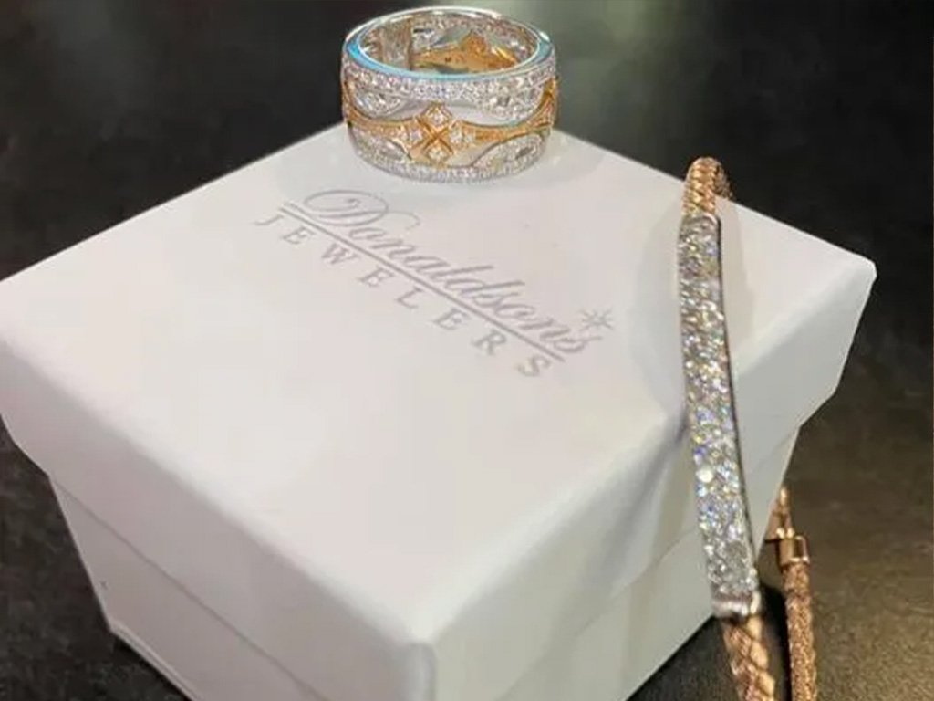 Jewelry set including a ring, a bracelet, and a necklace with diamonds, displayed on a white box with 'David's Bridal' logo.
