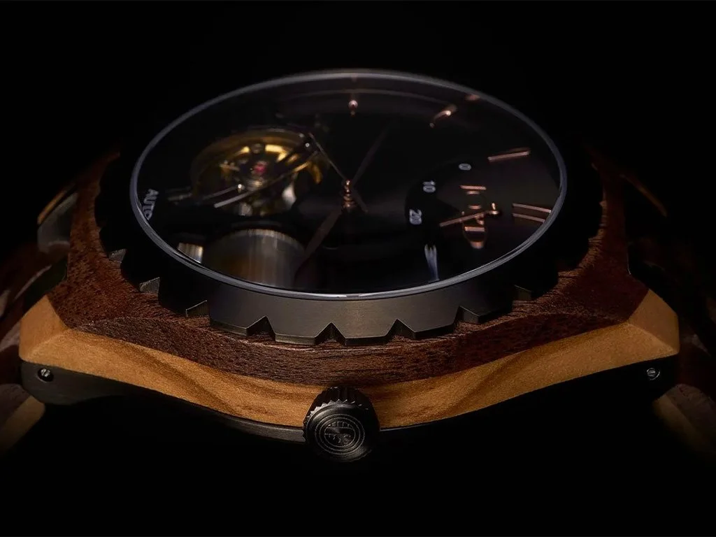 Close-up of a wristwatch with a dark dial, gold-toned and black accents, and a wooden case, against a black background.