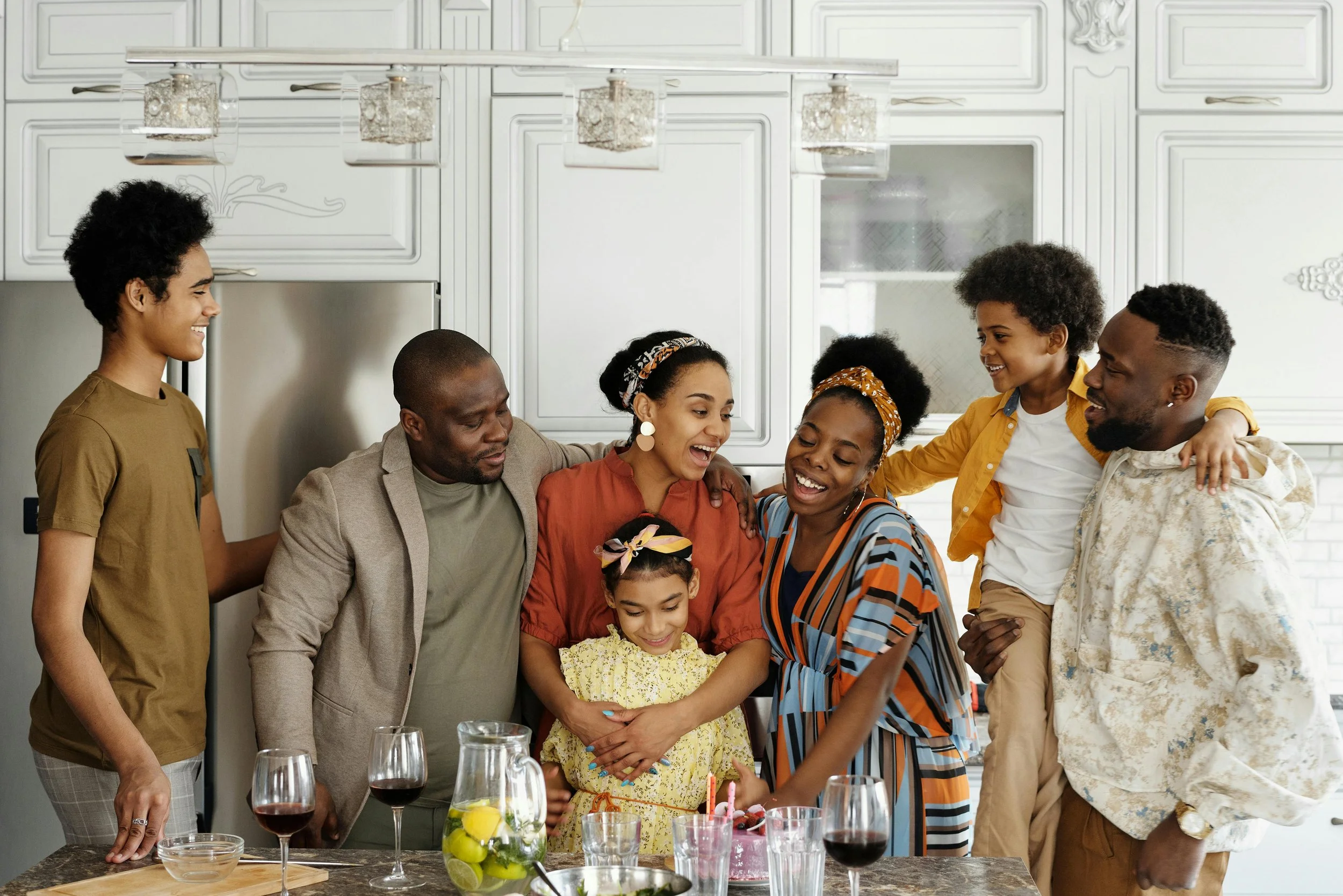A large family of multiple generations gathered happily in a kitchen, symbolizing healthy family dynamics and connection.