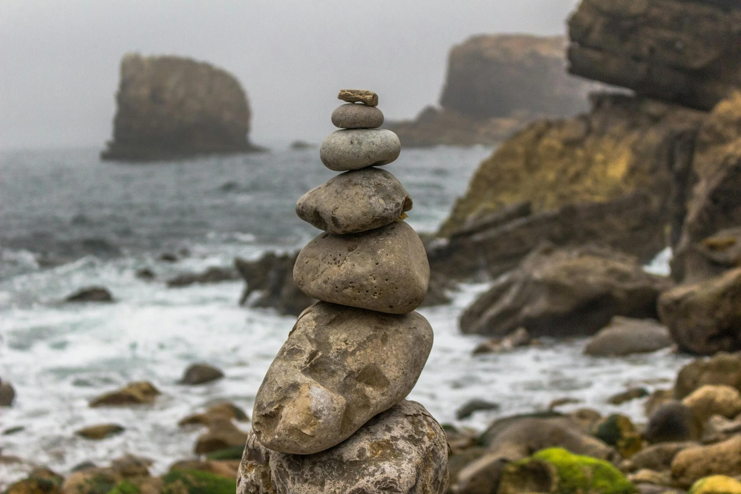 Balanced rocks on a beach, illustrating finding balance and relieving the feeling that everything is heavy.