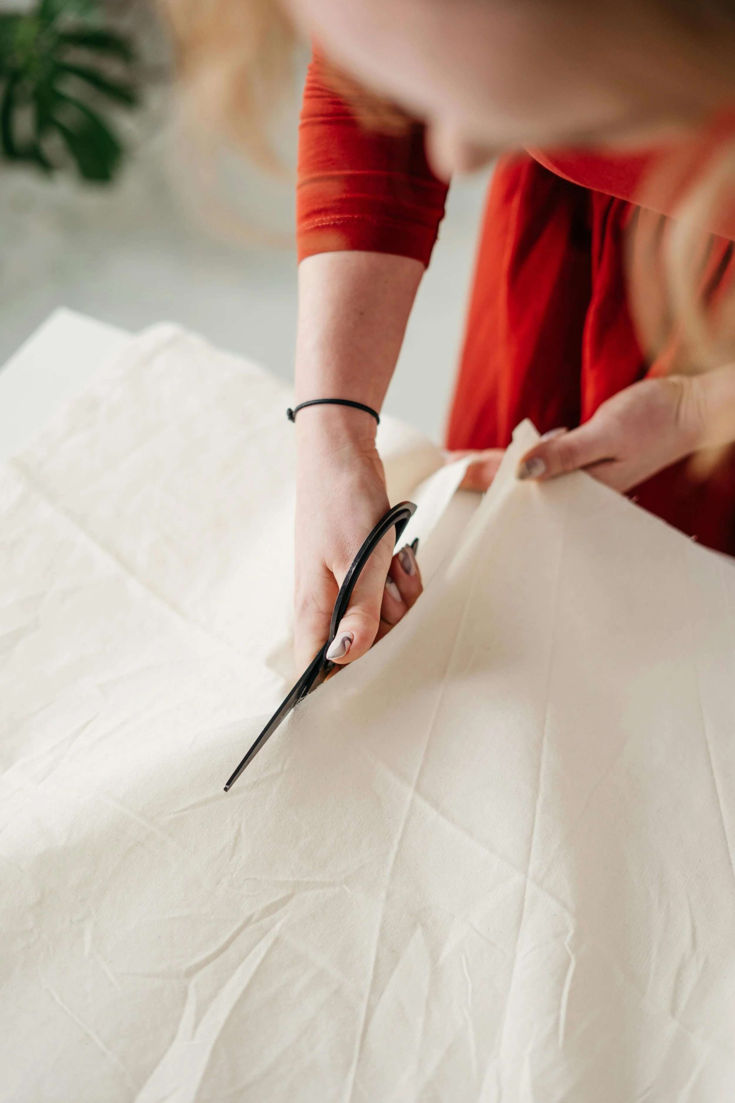 A person cutting through linen fabric, representing breaking through negative loops in therapy.